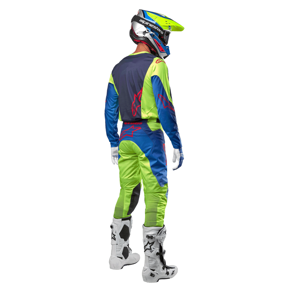 Alpinestars 2024 Racer Hoen Jersey i Yellow Fluo og Blue Night Navy, motocrosskører set bagfra med matchende bukser og hvide støvler, viser det bageste design med røde logoer, koordineret outfit til professionel terrænkørsel