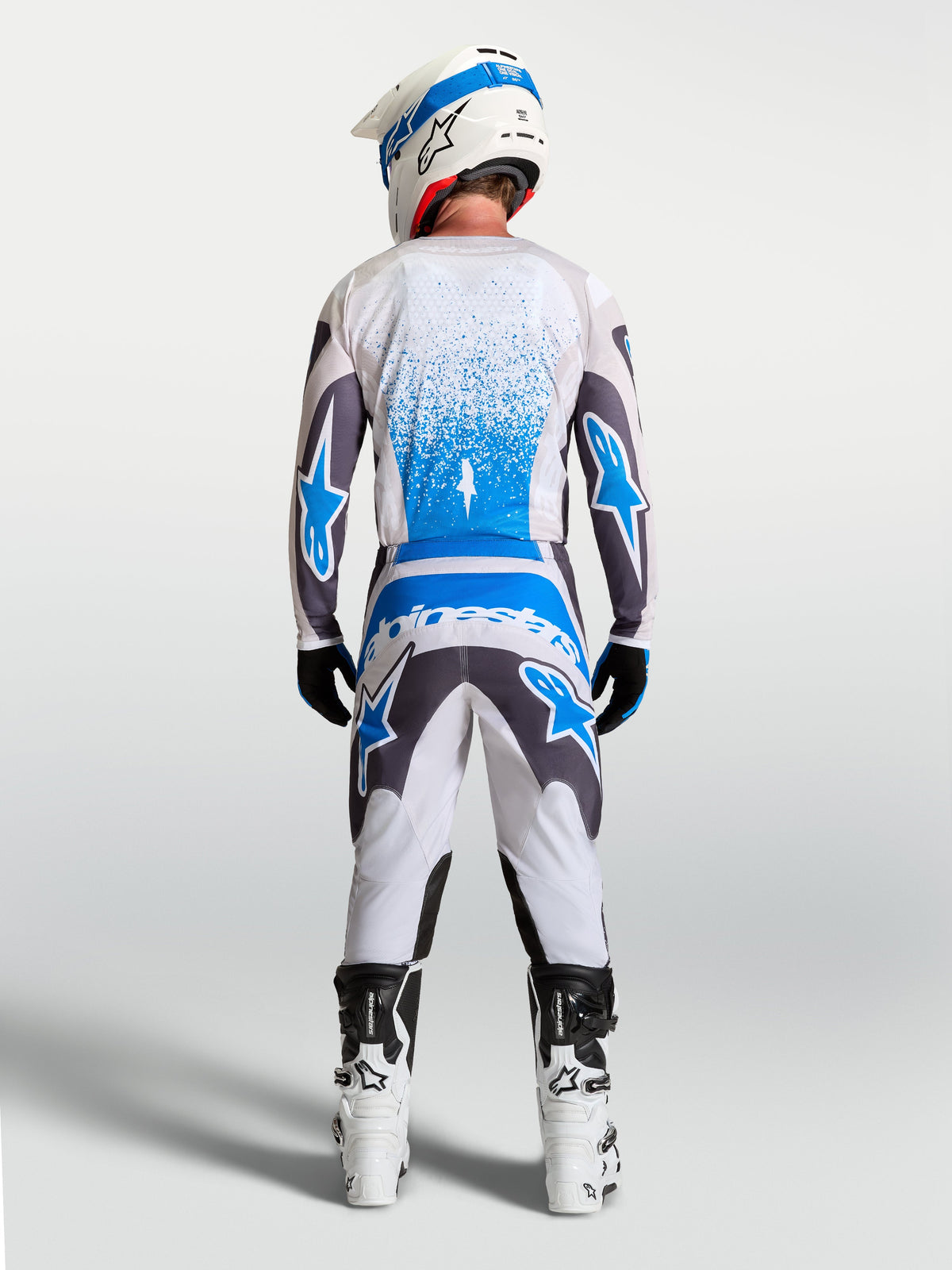 Alpinestars 2027 Fluid Drag gearsæt, herre-motocrosstrøje og bukser i hvid, grå og blå, set bagfra.