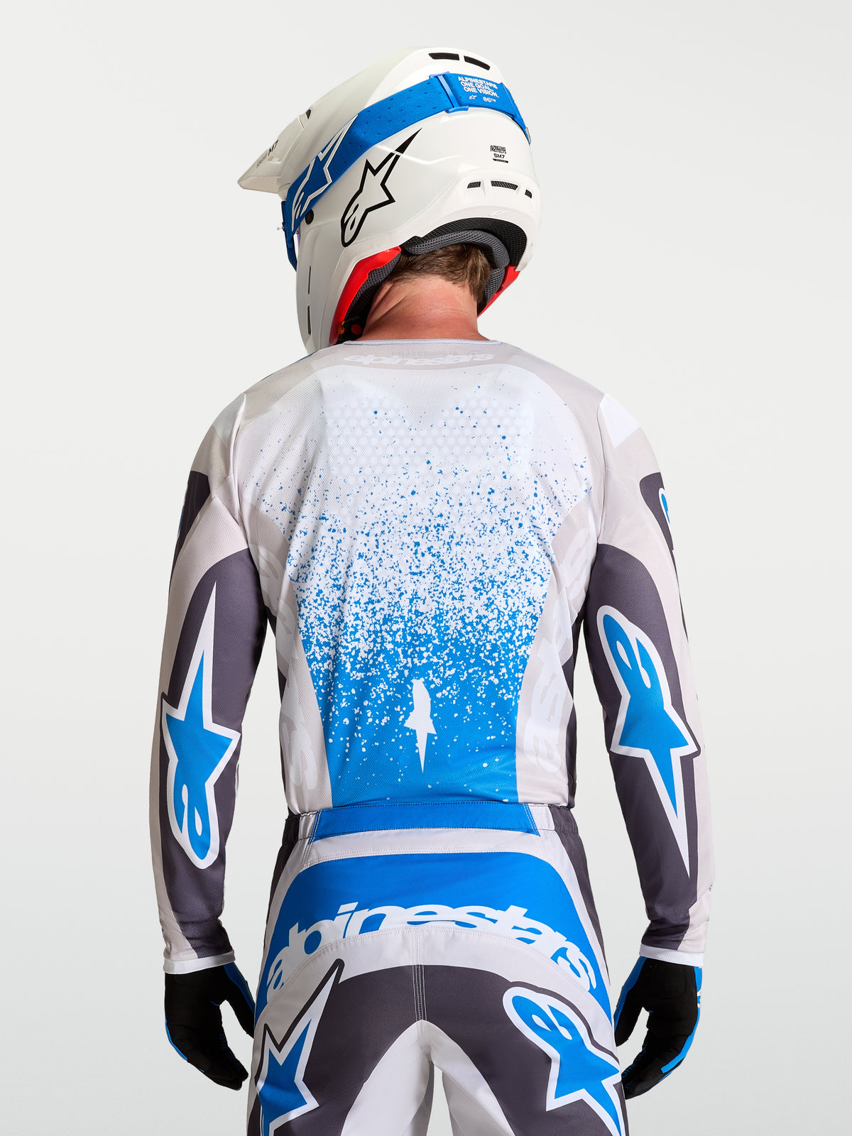 Alpinestars Fluid Drag trøje, åndbart herre-motocrosstøj i grå og blå, set bagfra.