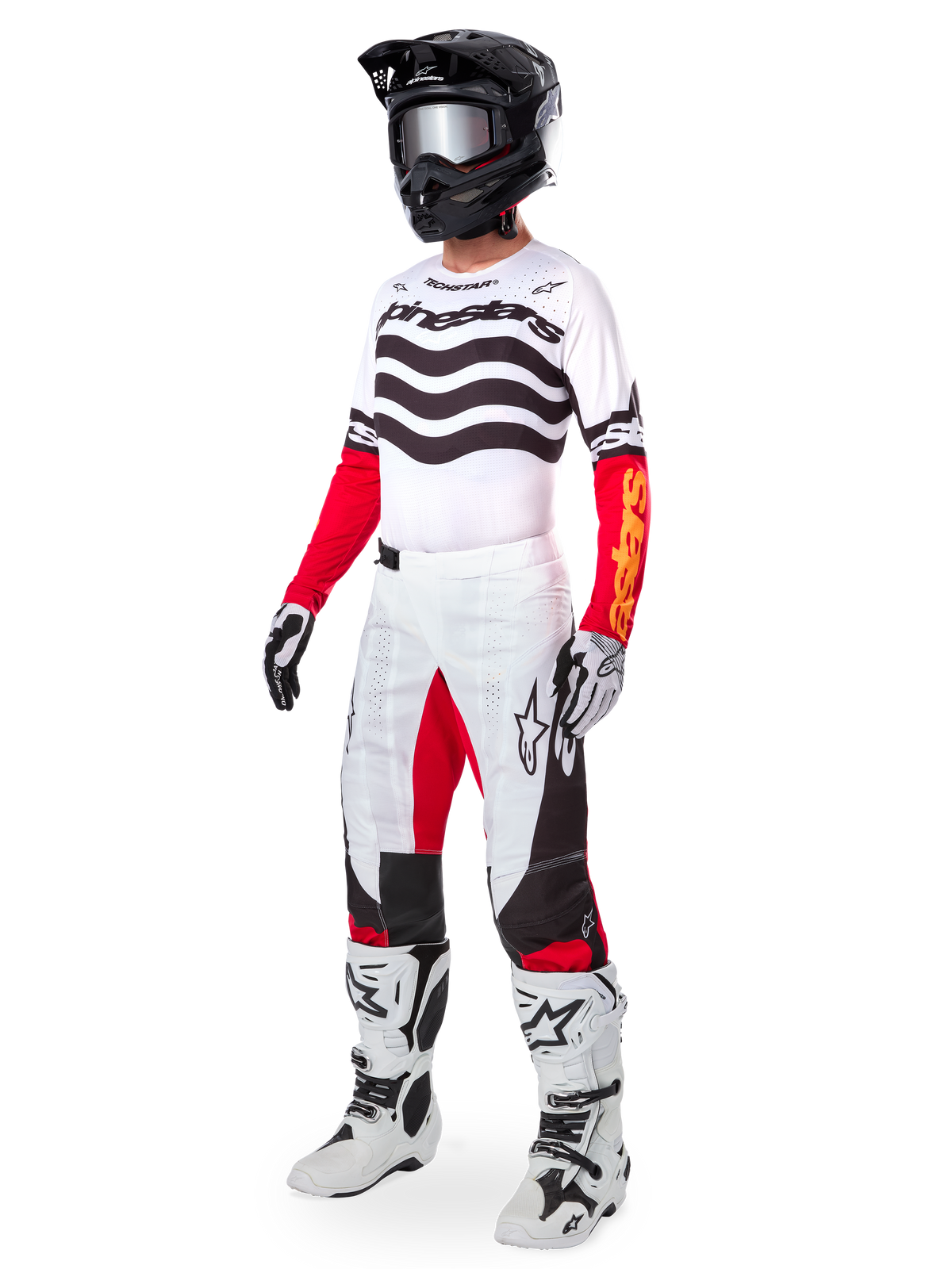 Motocrossrytter iført komplet racerudstyr, Limited Edition Techstar Deep-trøje med hvide og sorte bølgede striber og røde ærmer, matchende hvide og røde bukser, sort hjelm, hvide og sorte støvler, koordineret outfit til terrænkørsel