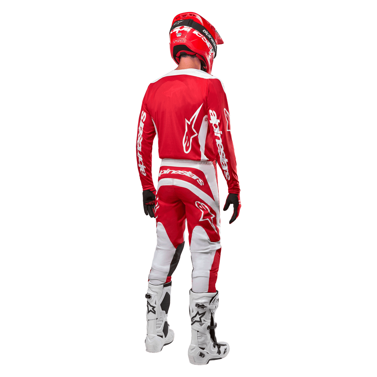 Bagfra-visning af en motocross-rytter iført Alpinestars 2024 Fluid Lurv trøje i Mars Red White, kombineret med matchende røde og hvide bukser, hvide off-road støvler og en rød hjelm, der viser trøjens rygdesign og Alpinestars-branding.