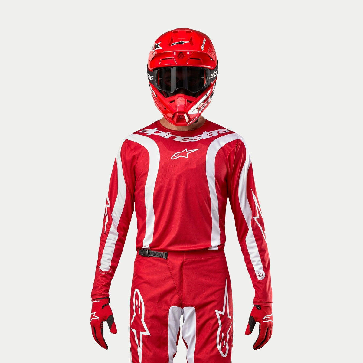 Alpinestars 2024 Fluid Lurv Jersey, motocross trøje, Mars rød og hvid, båret med matchende røde bukser, hjelm og handsker, med hvide grafiske detaljer på ærmerne og markant branding på brystet, atletisk pasform til off-road racing