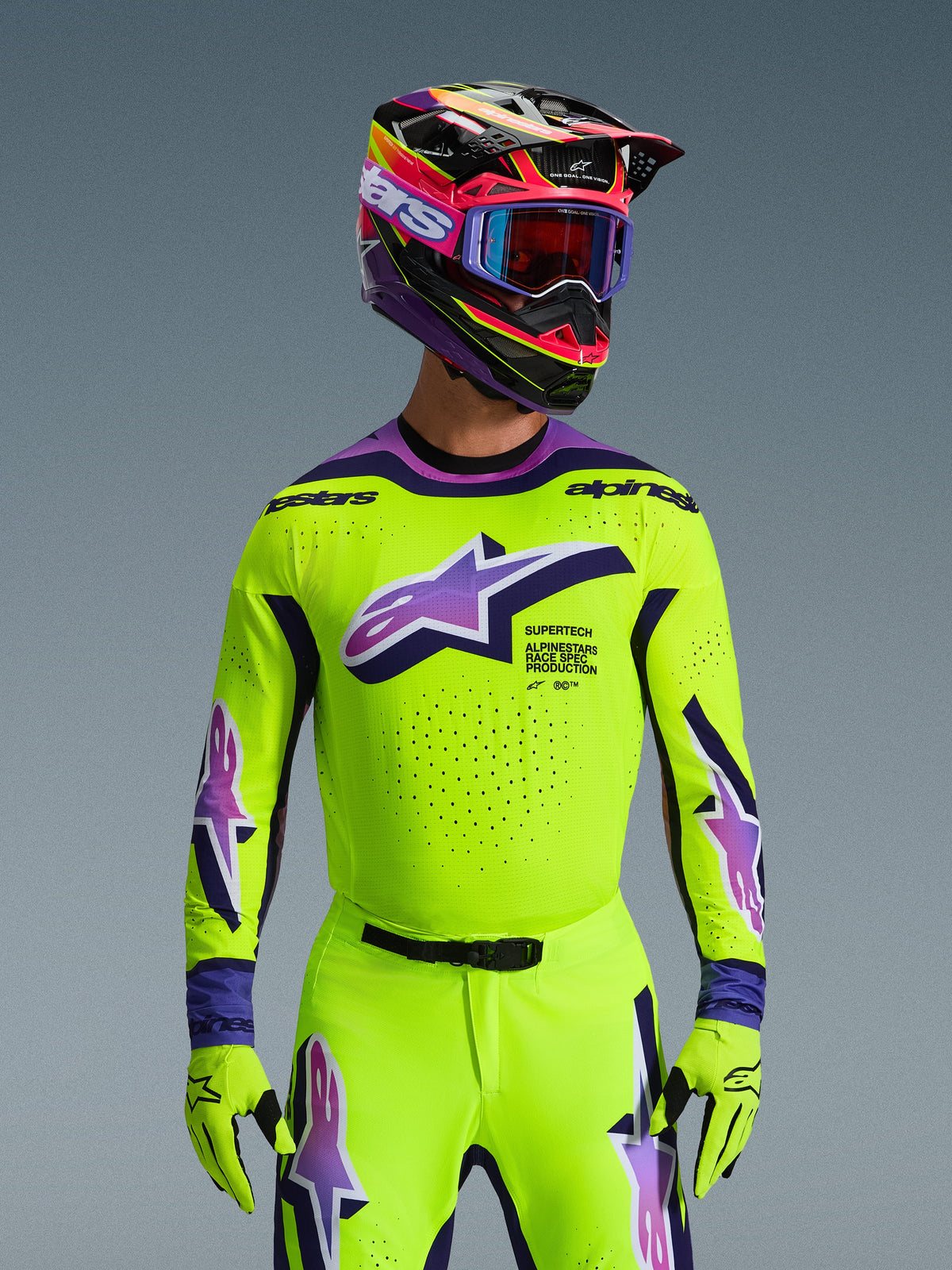 Alpinestars 2026 Supertech Vista udstyrssæt, motocross-kører iført neon-gul trøje og bukser med lilla og blå detaljer, stort Alpinestars-logo på brystet, matchende farverig hjelm og goggles, professionelt raceroutfit