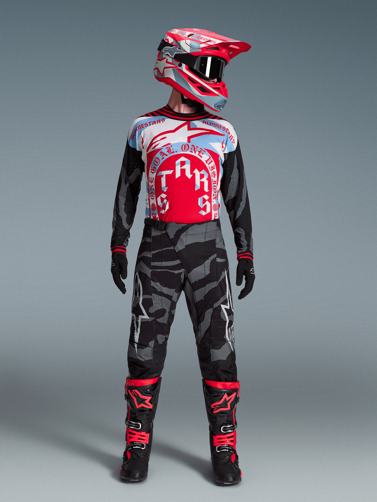 Techstar Beast Coast Trøje Begrænset Udgave i rød, hvid og blå, vist med motocross-hjelm og grå camouflage-bukser.