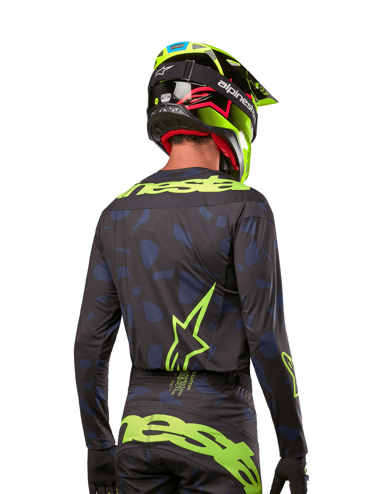 Set bagfra af en motocross-rytter iført Alpinestars 2024 Techstar Rantera Jersey i Black Navy Yellow Fluo, med fremtrædende gul fluo-branding og logoer på ryggen, kombineret med matchende motocross-bukser og en neongul hjelm for et komplet off-road racing-look.