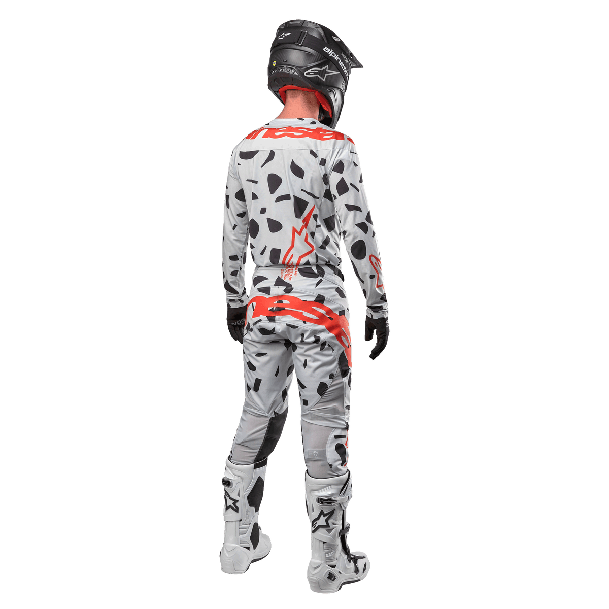 Motocrossrytter set bagfra, iført Alpinestars 2024 Techstar Rantera trøje og matchende bukser, Haze Gray Camo-mønster med markante røde Alpinestars-logoer, sort hjelm, hvide og sorte støvler, sorte handsker, koordineret motocross-udstyrssæt