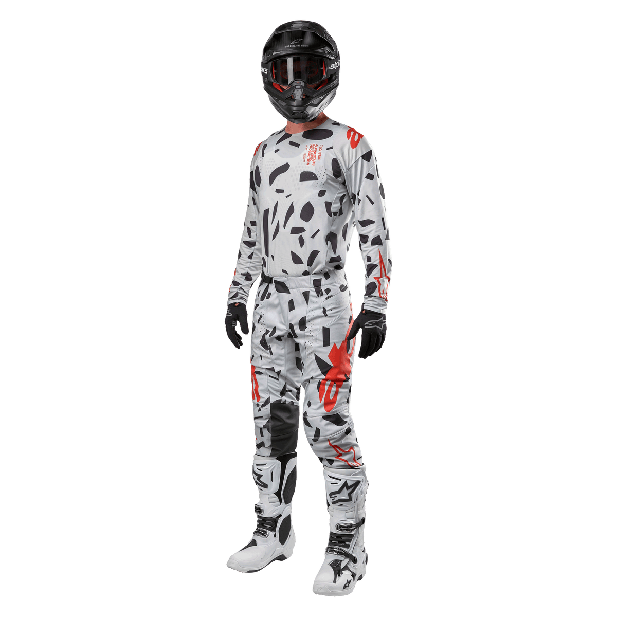 Motocrossrytter iført Alpinestars 2024 Techstar Rantera-trøje i Haze Gray Camo, matchende bukser med røde og sorte detaljer, sort hjelm og goggles, sorte handsker, hvide og sorte støvler, komplet koordineret motocross-racerudstyr til terrænkørsel