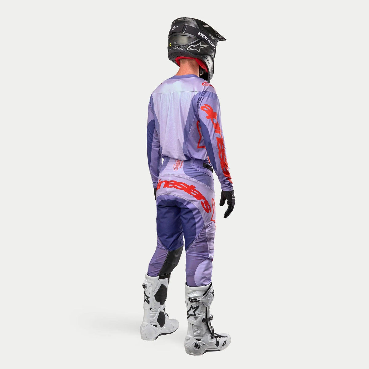 Alpinestars 2024 Techstar Ocuri Gear Set, komplet motocross-udstyr, lilla og orange, lilla jersey med røde detaljer, lilla og mørkeblå bukser med orange logo, sort hjelm, hvide støvler, set bagfra, professionelt udstyr til terrænkørsel