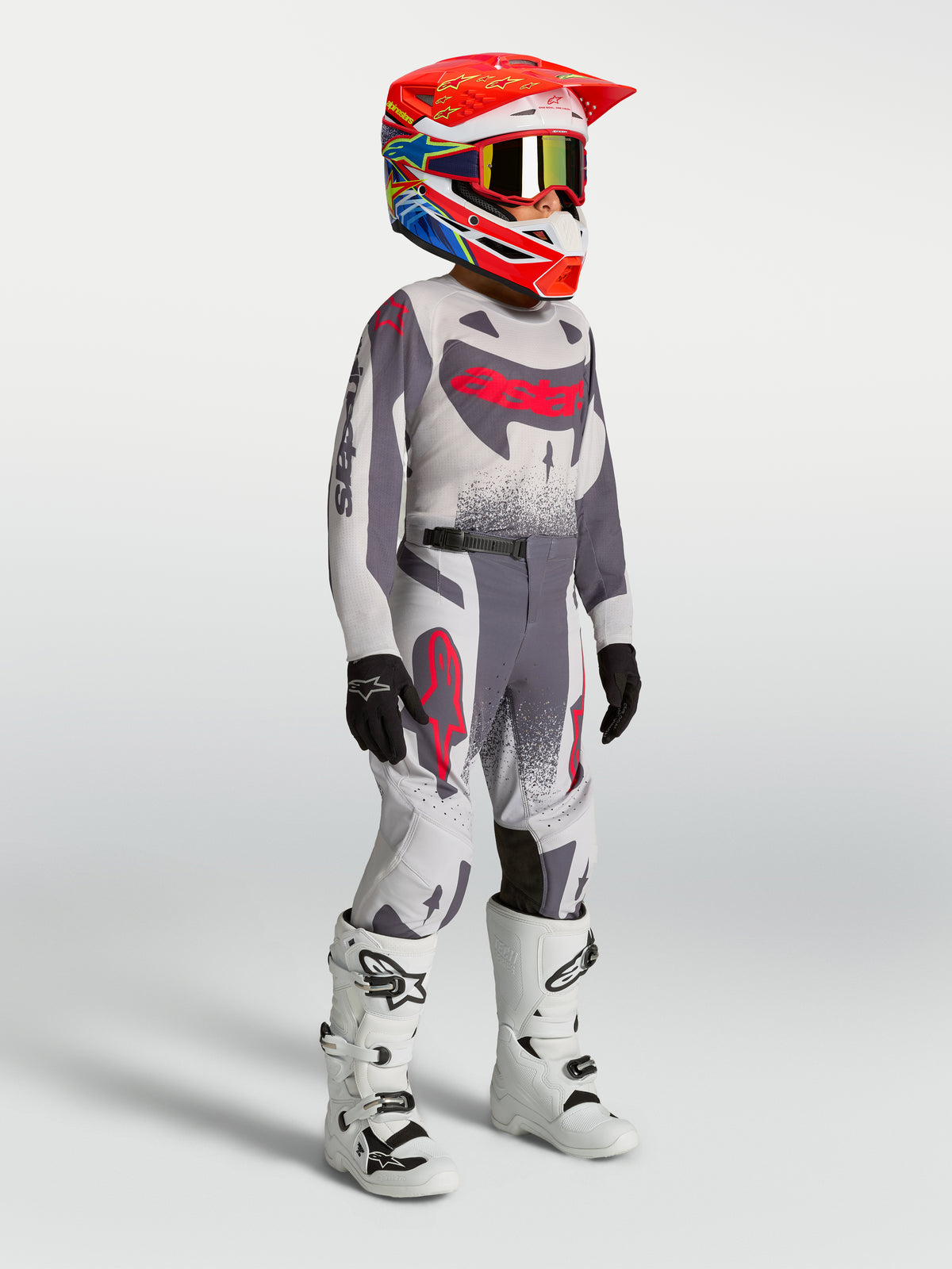 Alpinestars Supertech Swan trøje og sæt til ungdom, grå og rød motocrossbeklædning med hvide støvler.
