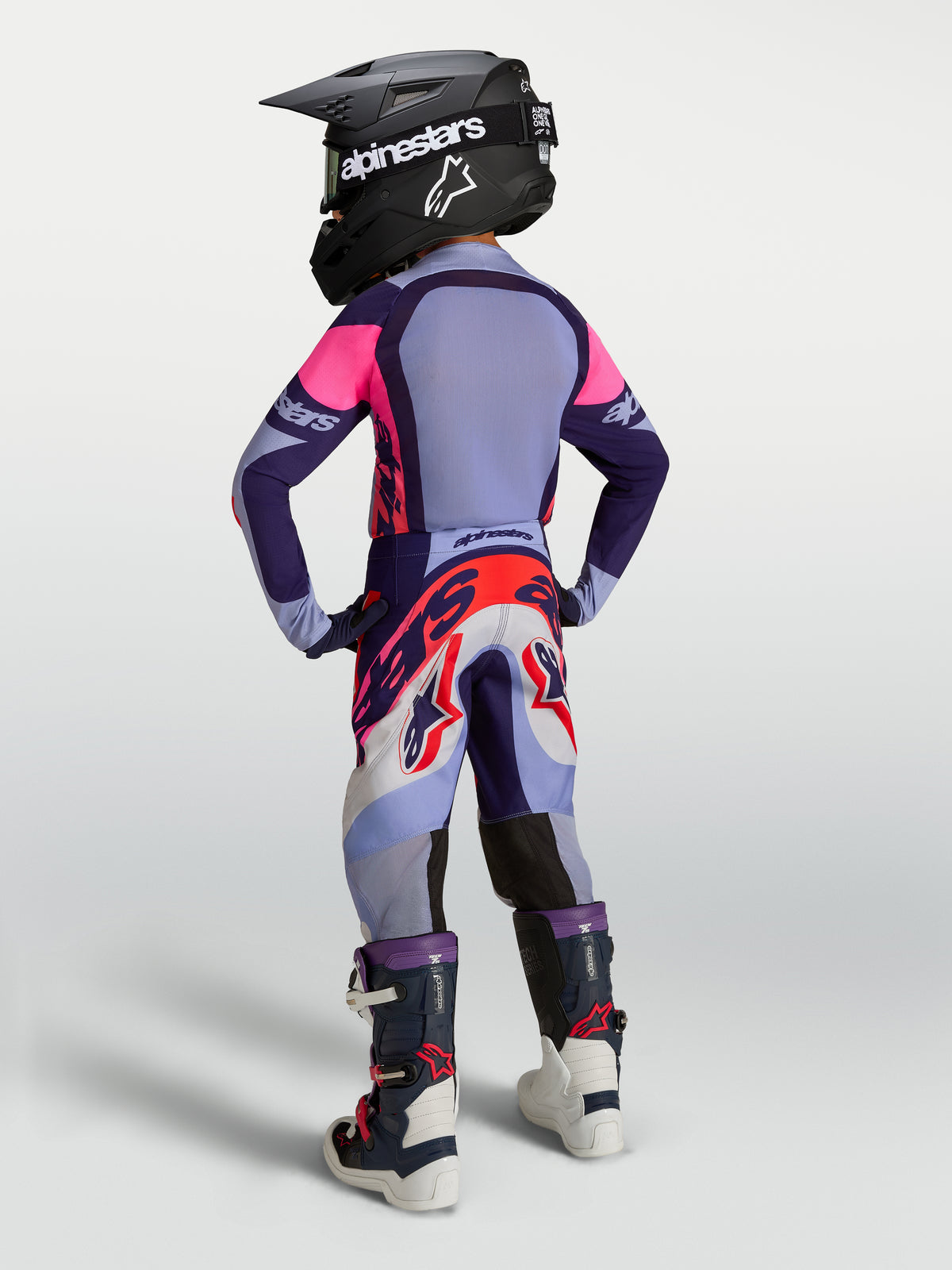 Alpinestars Ungdom Supertech Dyna Gear Set, lilla og pink motocross-sæt med trøje, bukser, støvler og hjelm, set bagfra.