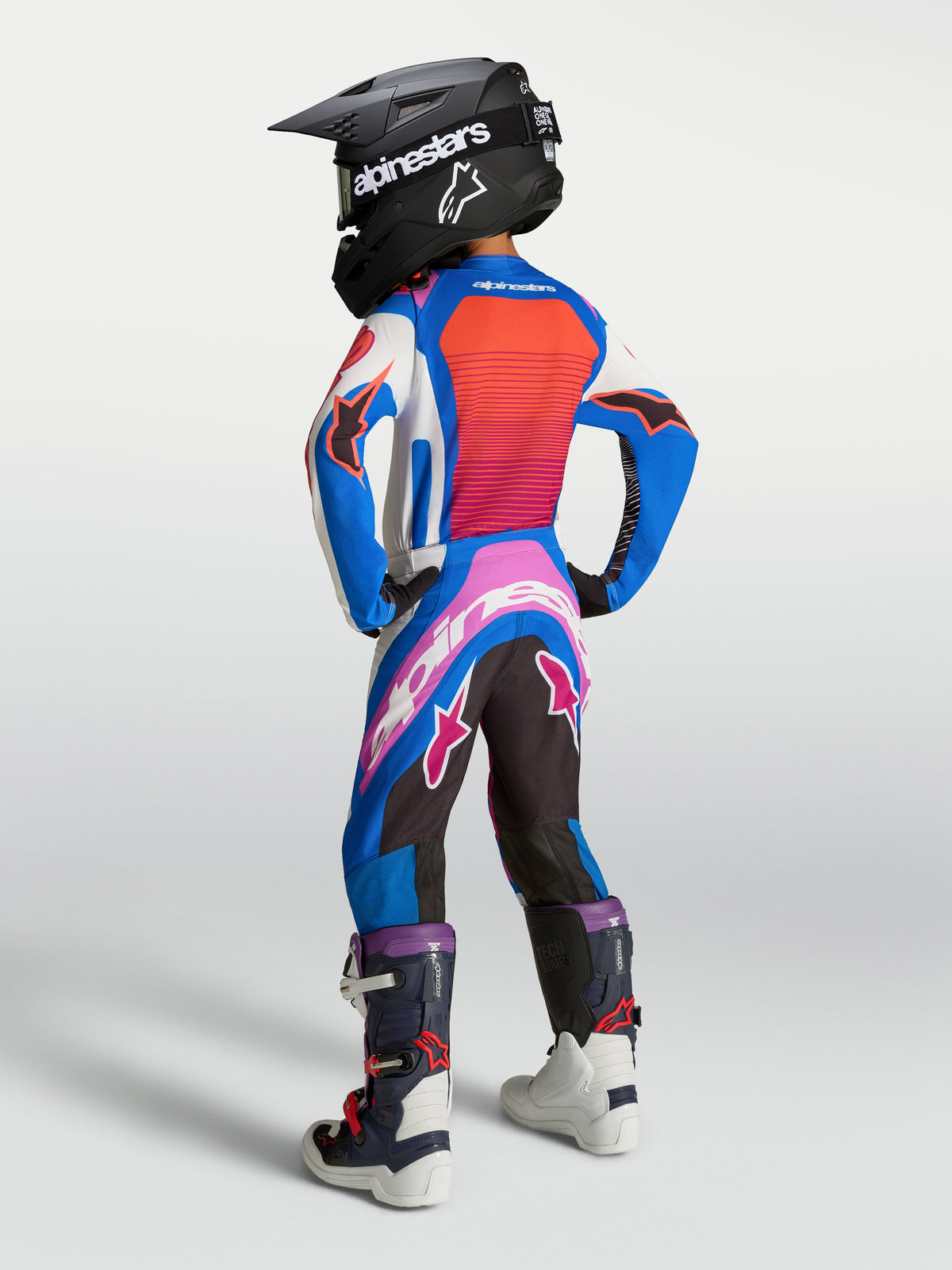 Alpinestars 2027 Youth Supertech Maven Jersey and Gear Set, Blue and Hot Coral motocross outfit, rear view on young rider.
