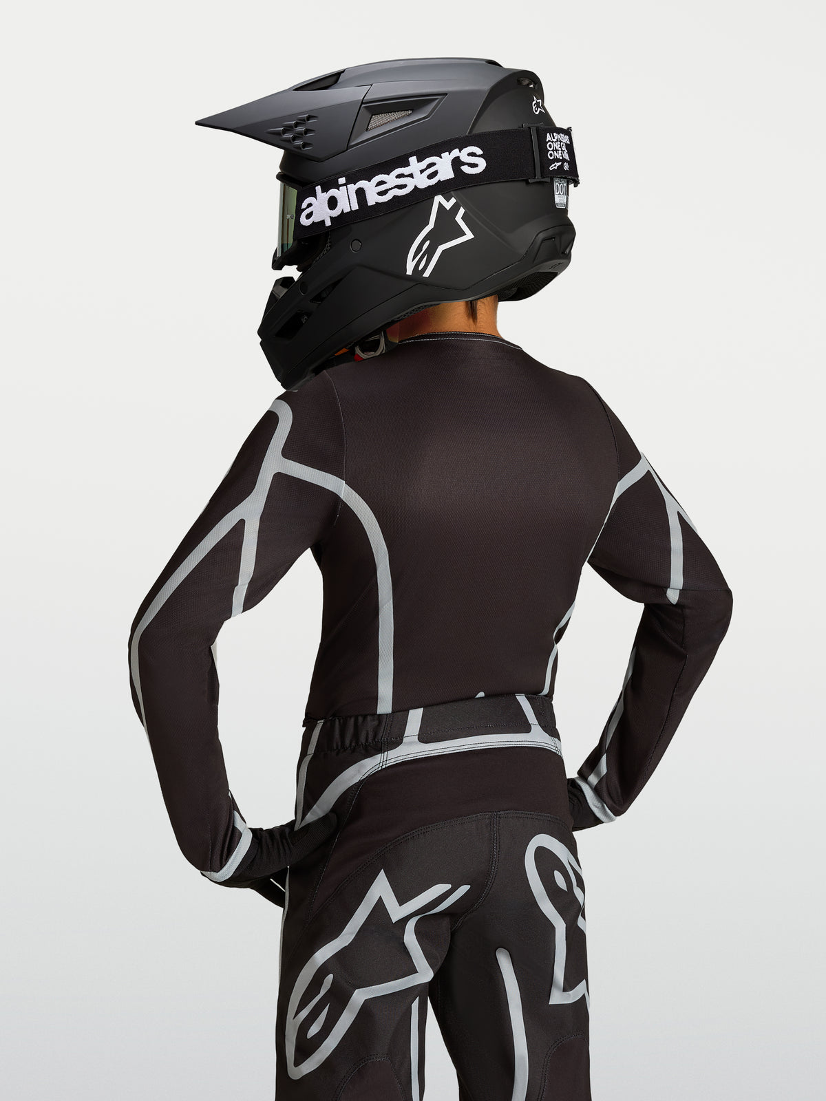 Alpinestars Youth Fluid Apex V2 trøje, sort og sølv motocrosstrøje til unge, set bagfra med ergonomisk atletisk snit