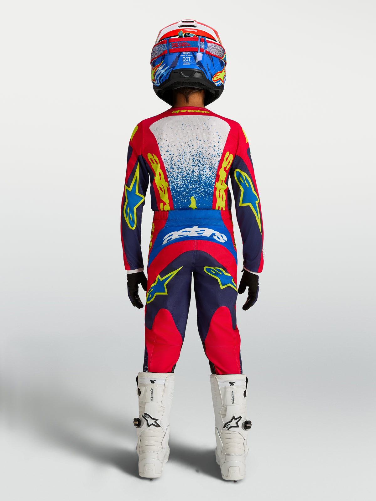 Alpinestars 2027 Fluid Drag trøje og udstyrssæt til ungdom, motocross-sæt, mørkeblå og rød, set bagfra på en rytter.