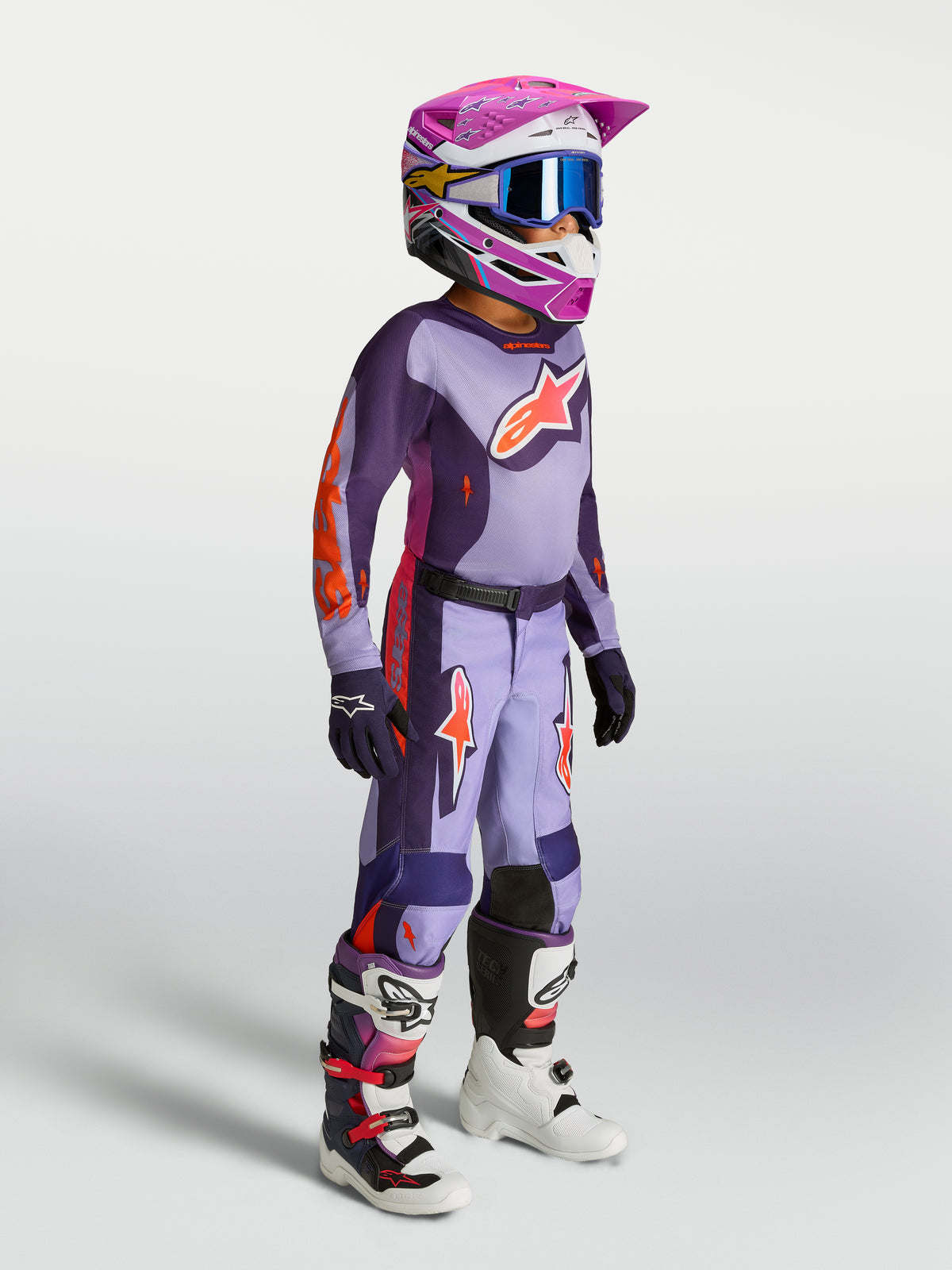 Alpinestars 2027 ungdom Fluid Hunt udstyrssæt, lilla og pink motocrosstrøje og bukser på model til off-road racing.