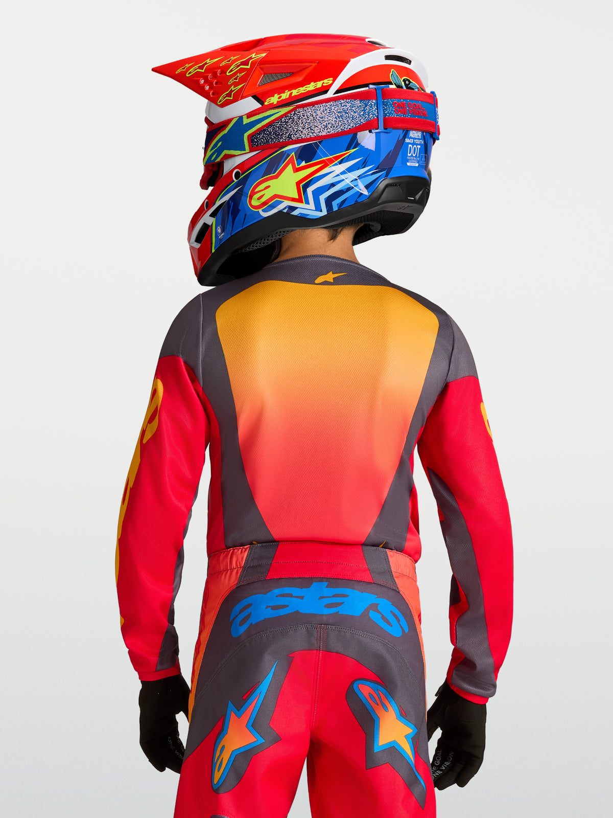 Alpinestars 2027 Fluid Hunt trøje ungdom, rød og grå fugttransporterende motocrosstrøje set bagfra på en ung rytter.