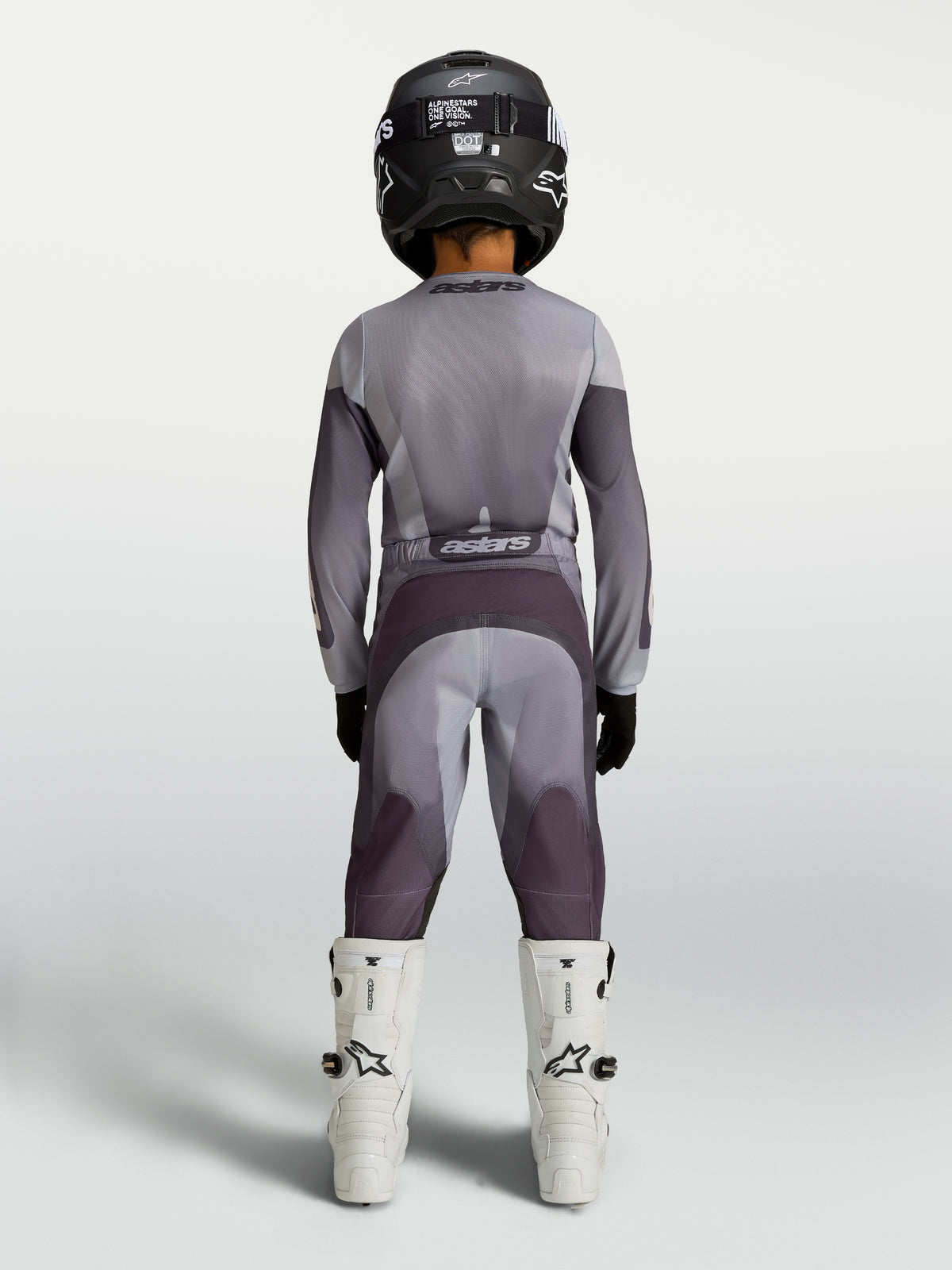 Alpinestars 2027 Fluid Amber trøje og udstyrssæt til ungdom, gråt og lilla motocrossudstyr, set bagfra på rytter.