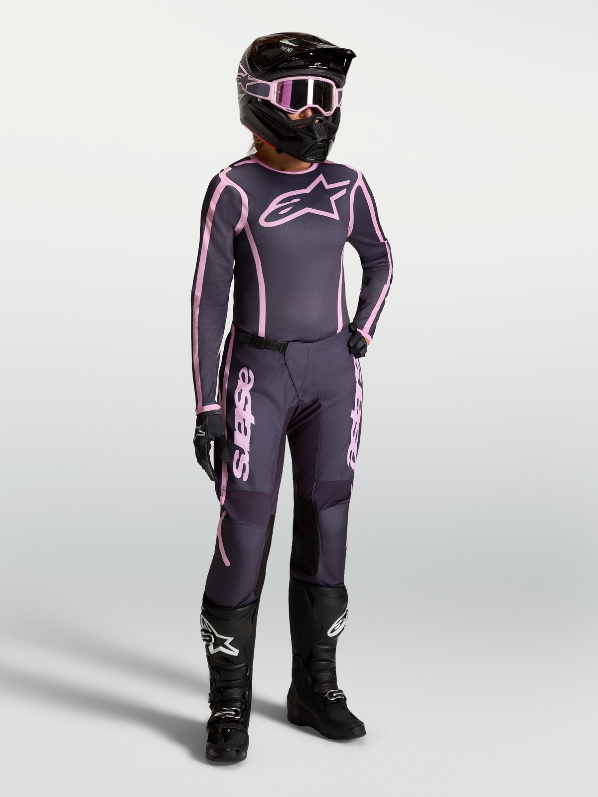 Alpinestars Stella Fluid Apex V2 trøje og udstyrssæt i grå og pink, dame-motocrossudstyr med sorte motorcykelstøvler.