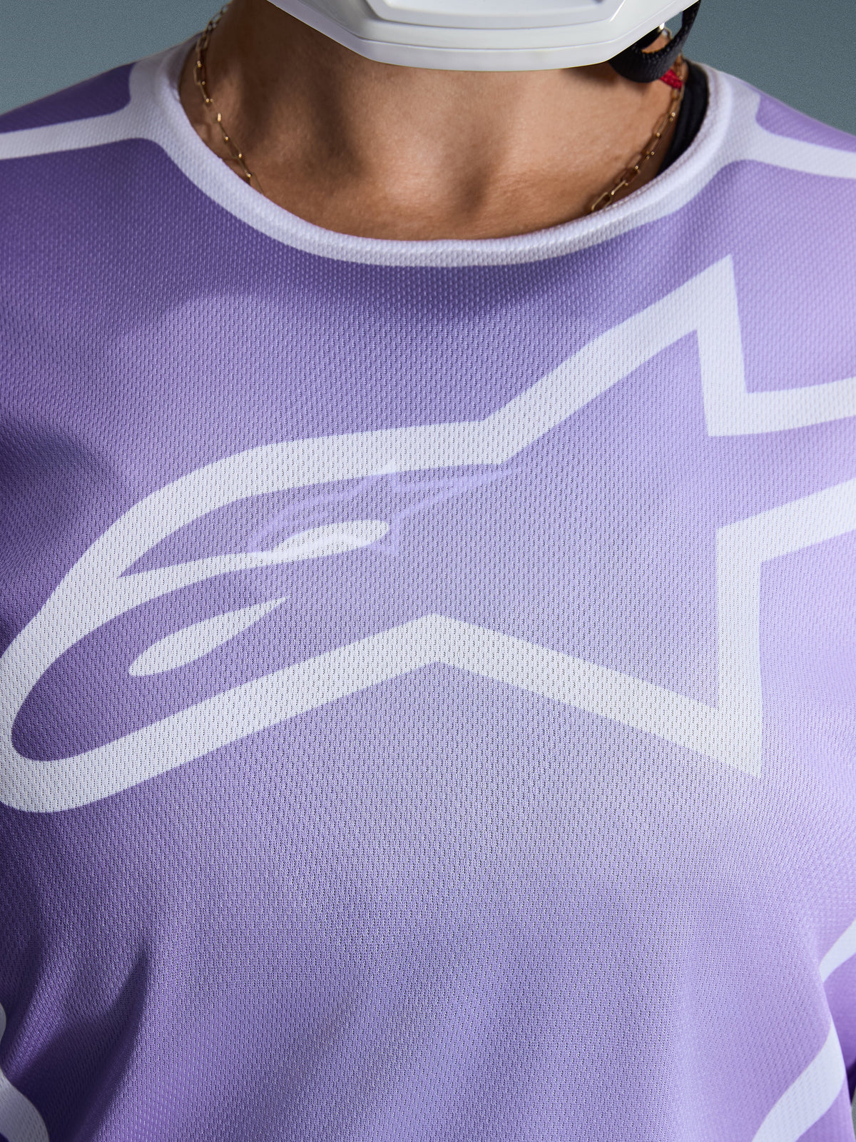 Alpinestars 2026 Stella Fluid Apex trøje, nærbillede af brystet, lilla med hvid grafik, stort hvidt Astars-logo, åndbar mesh-polytekstilkonstruktion, motocross-udstyr til damer