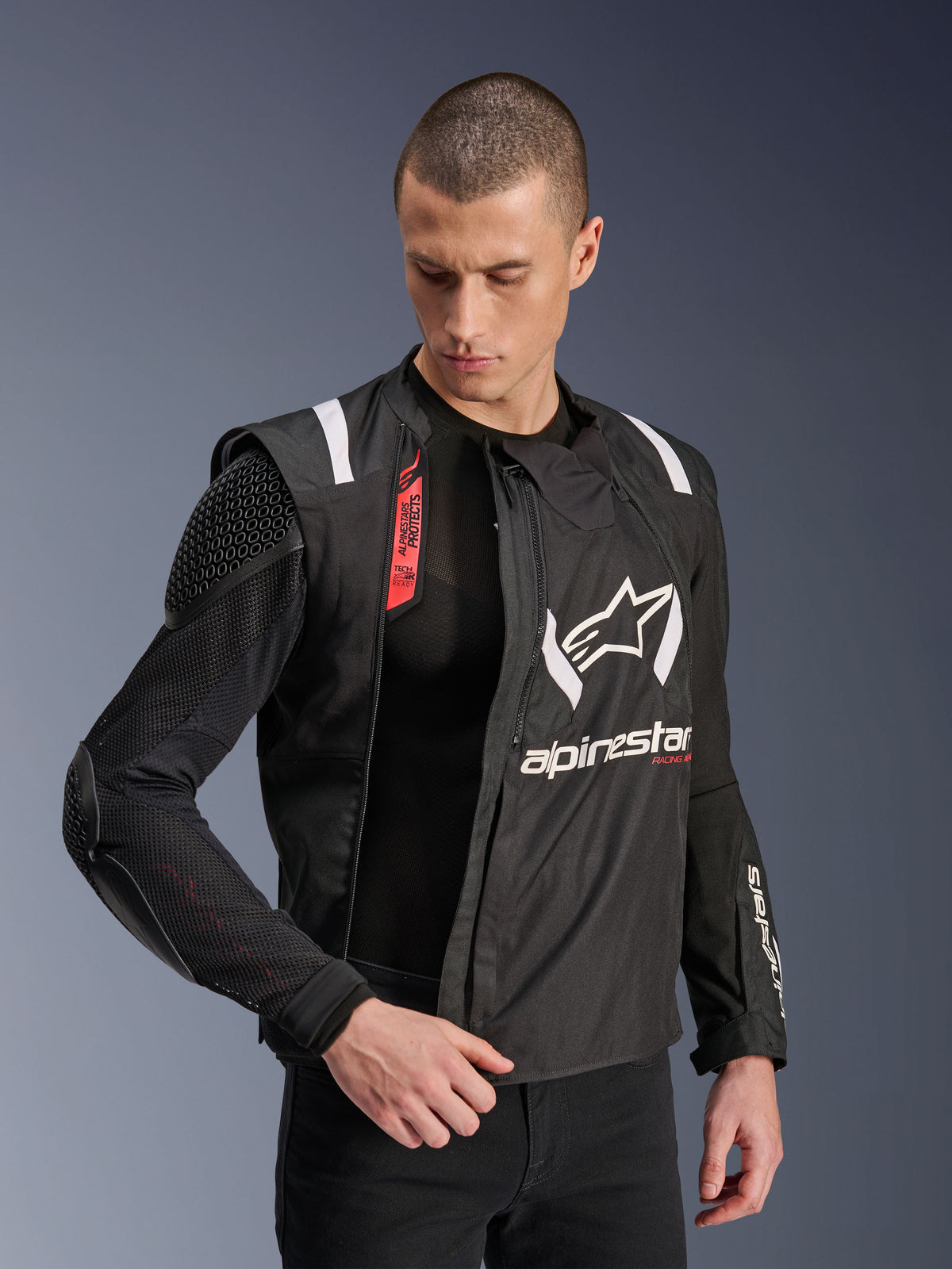 Alpinestars T-Stunt Air-jakke, sort og hvid motorcykeljakke, båret af mandlig model, der viser modulær mesh-konstruktion og synlig indvendig beskyttelse på skulder og albue, Alpinestars-logo på brystet, Tech-Air®-klar, sportssnit til landevejskørsel