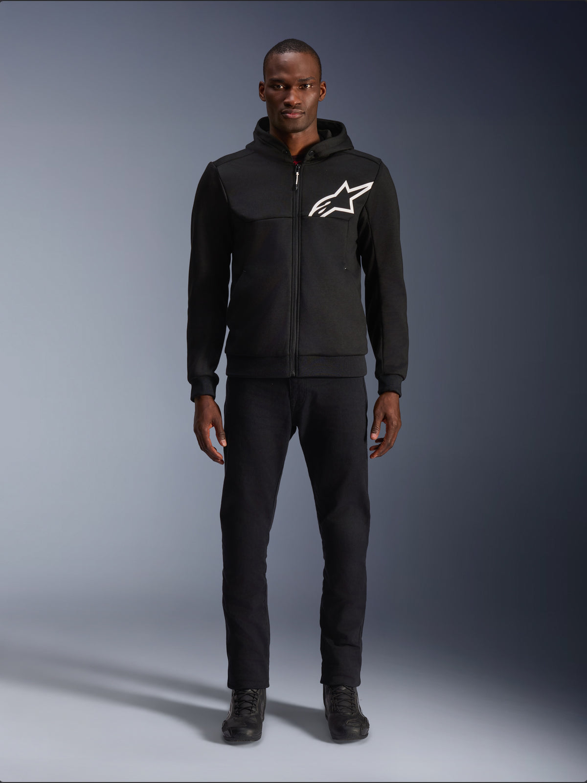 Alpinestars Chrome V2 Sport hættetrøje, sort herremotorcykeljakke i urban stil med hvidt logo og tech fleece, båret af model