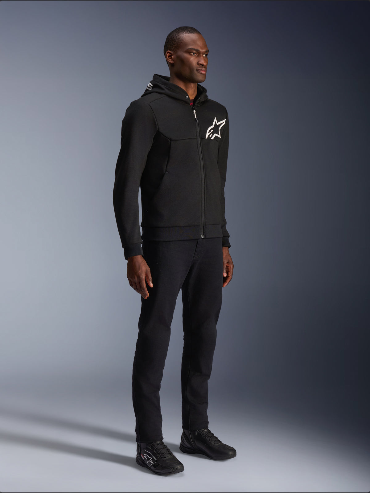 Alpinestars Chrome V2 Sport hættetrøje, urban motorcykeljakke til herrer, sort og hvid, tech fleece med aramidforstærkning, CE-certificeret, Tech-Air® Ready, båret af mandlig model.