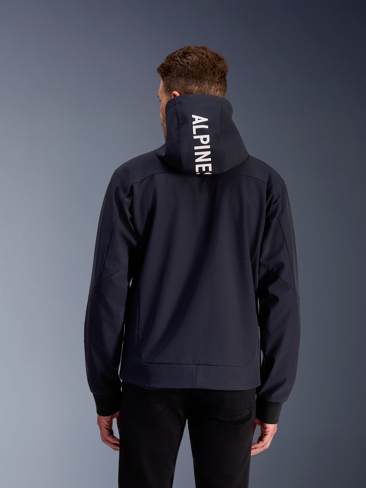 Alpinestars Radium Tech Hættetrøje, sort og hvid herre-motorcykeljakke i 3L tekstil, set bagfra med logo på hætten