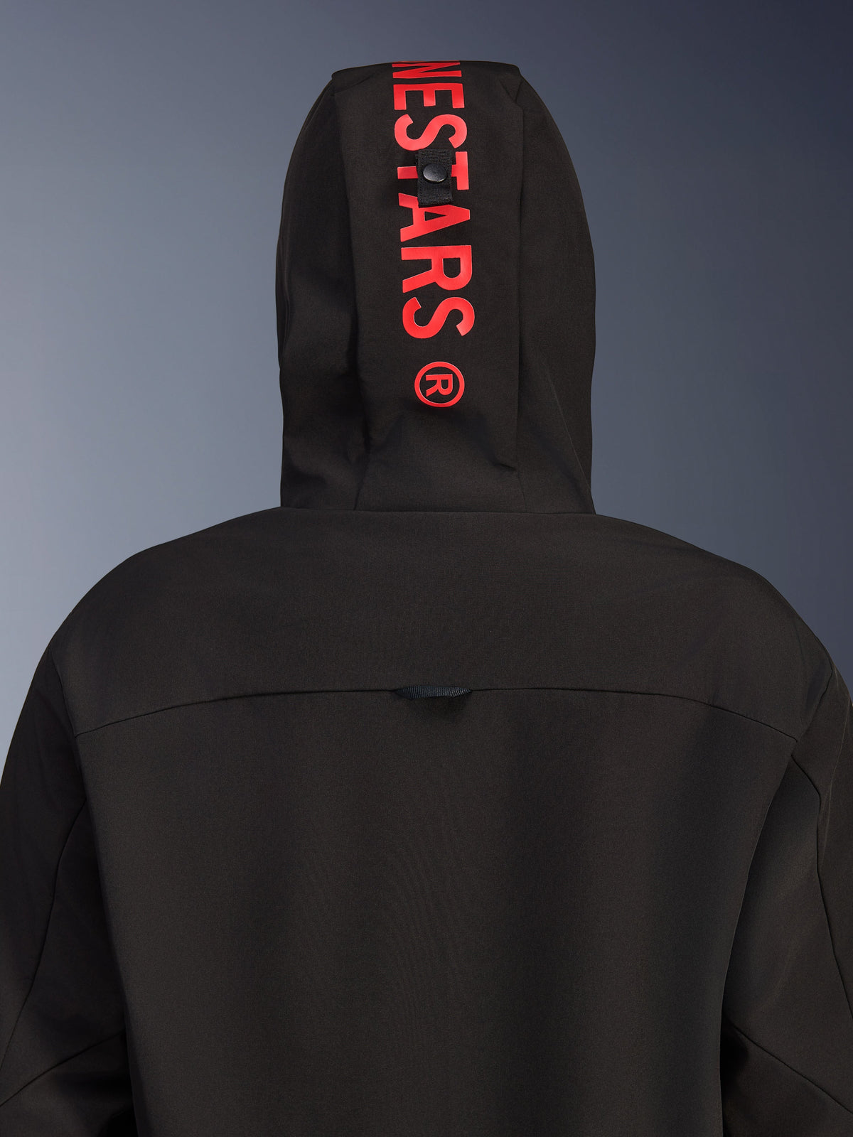 Alpinestars Radium Tech Hoodie, urban motorcykeljakke, sort med klar rød, set bagfra med fokus på hætten med lodret rød logo-branding, vindtæt tekstilskal og moderne design.
