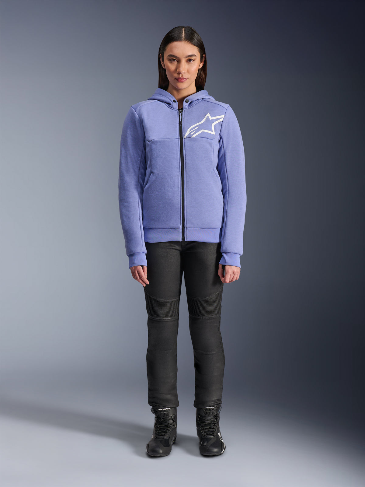Alpinestars Stella Chrome V2 Sport hættetrøje til kvinder, Blue Violet med hvidt Astars-logo på brystet, teknisk fleece med gennemgående lynlås og hætte, båret med sorte motorcykelbukser og kørestøvler, afslappet urbant køreudstyr til damer