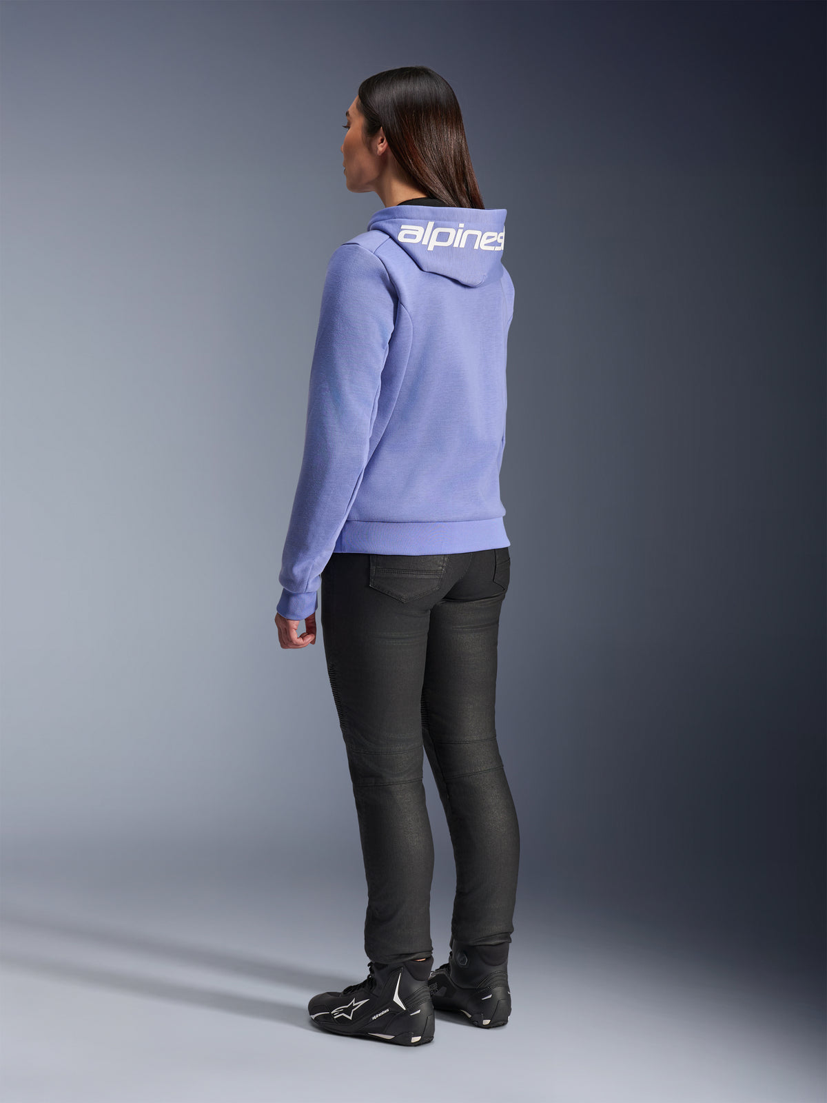 Alpinestars Stella Chrome V2 Sport hættetrøje til kvinder, Blue Violet, set bagfra med hvid branding på hætten, båret med sorte kørebukser og sorte motorcykelstøvler, afslappet urbant motorcykeludstyr