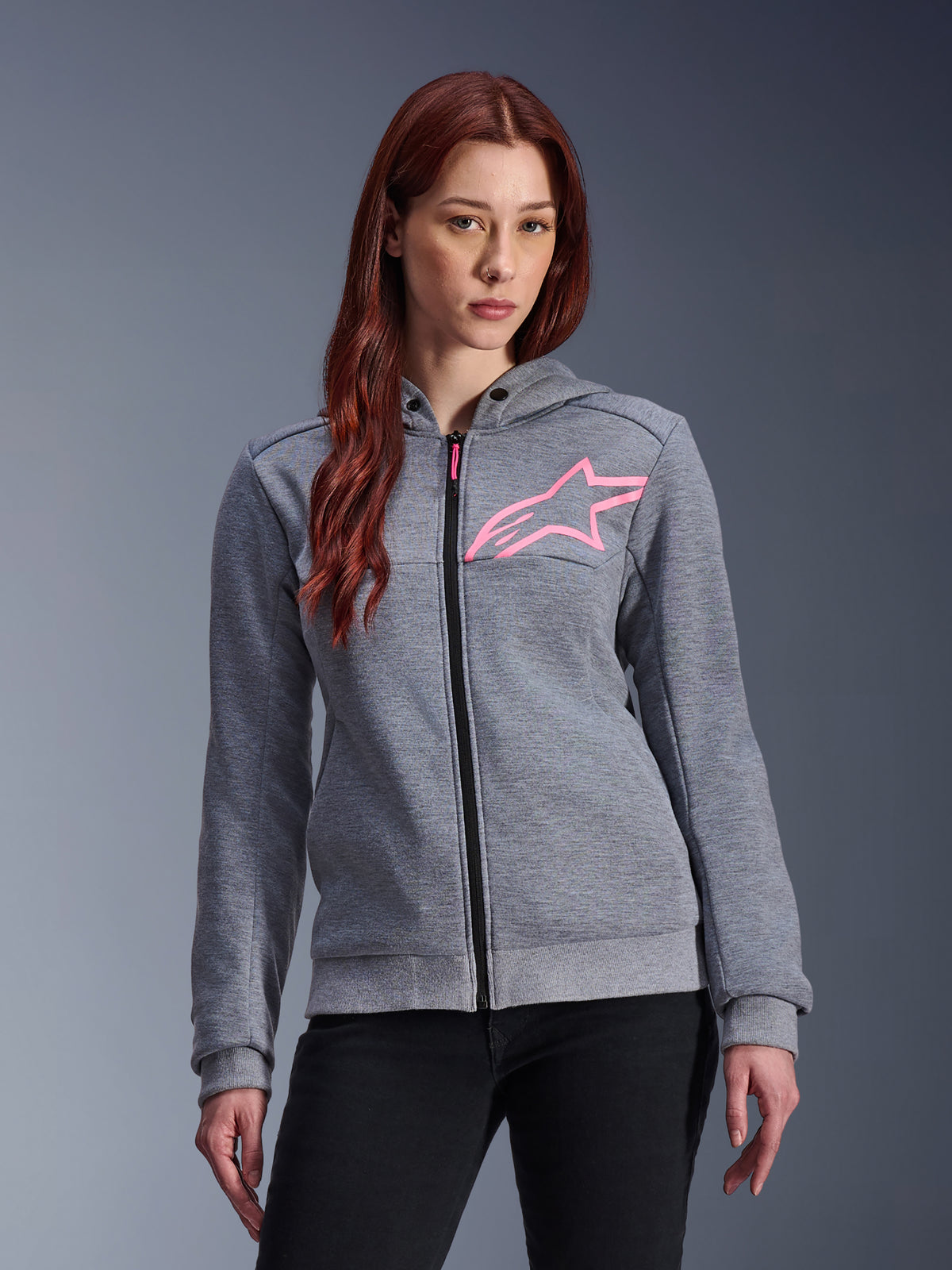 Alpinestars Stella Chrome V2 Sport hættetrøje, motorcykelhættetrøje til damer, gråmeleret med pink fluo stjerne-logo, tech-fleece materiale med ribbede manchetter og kant, sort lynlås foran med pink vedhæng, afslappet urbant streetwear til kørsel båret med sorte bukser