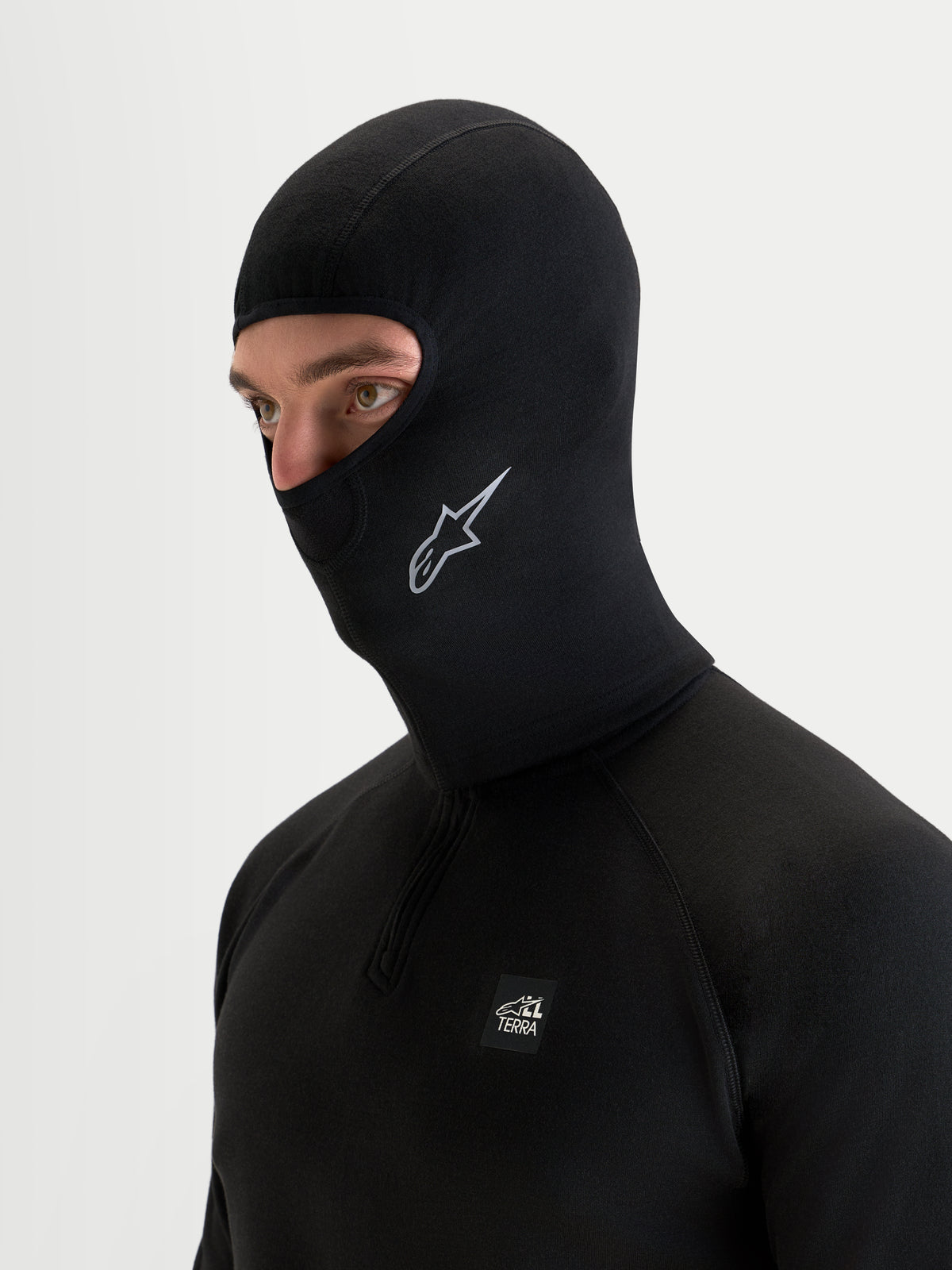 Alpinestars At 8 Merino Balaclava, sort motorcykel-balaclava båret af mandlig model, der viser merinoblanding og forlænget halsdækning til koldt vejr