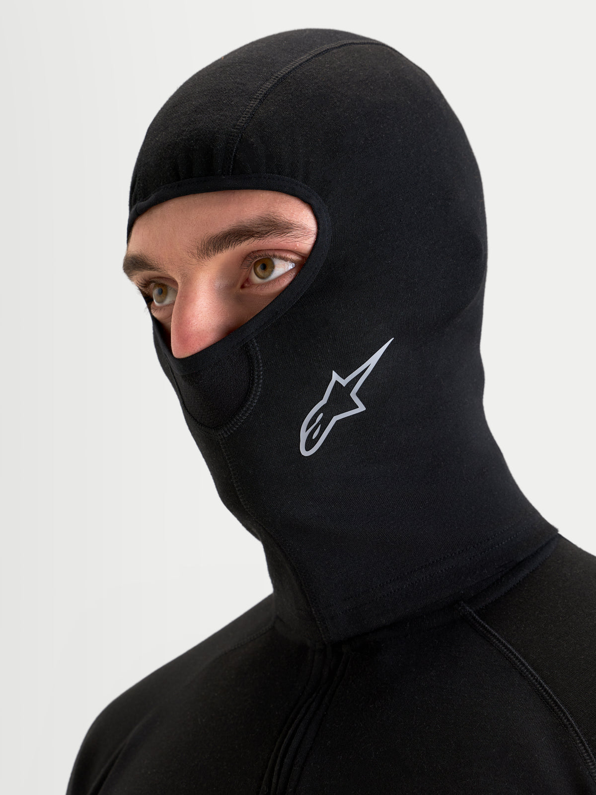 Alpinestars At 8 Merino balaclava, sort motorcykel termobasisland balaclava båret af model, med merinoblanding, flade sømme og trykt Astar-logo
