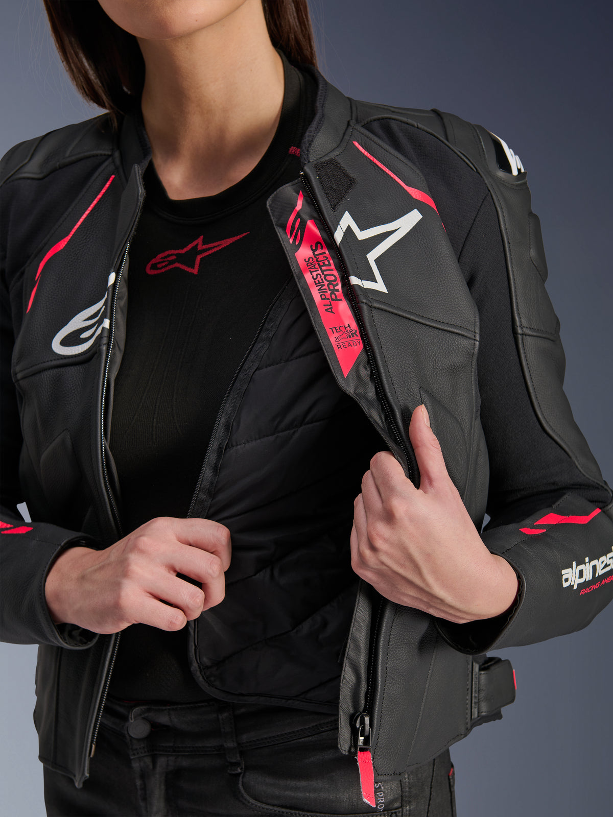 Alpinestars Stella Dusk læderjakke til kvinder, sort, Diva Pink og hvid, motorcykel-læderjakke lynet op for at vise den indvendige vatterede termiske foring og Tech-Air Ready-branding, med hvide logoer og livlige lyserøde detaljer