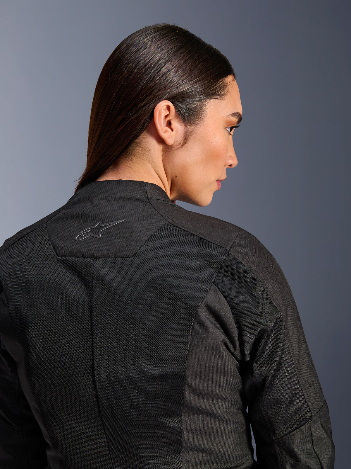 Alpinestars Stella C-1 Air jakke til damer, tekstil motorcykeljakke, sort, nærbillede bagfra der viser tech mesh-ventilationspaneler og et reflekterende stjernelogo på øverste del af ryggen, moderne urbant køreudstyr