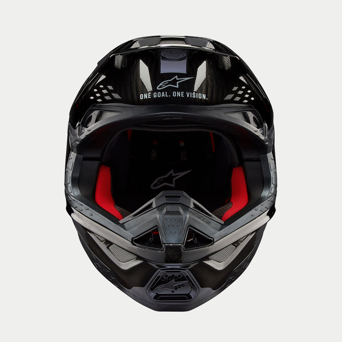 Alpinestars Supertech M10 Solid hjelm, motocrosshjelm, sort blank kulfiber, set forfra med rødt indvendigt for, kulfiberskal og "ONE GOAL. ONE VISION." slogan på visiret