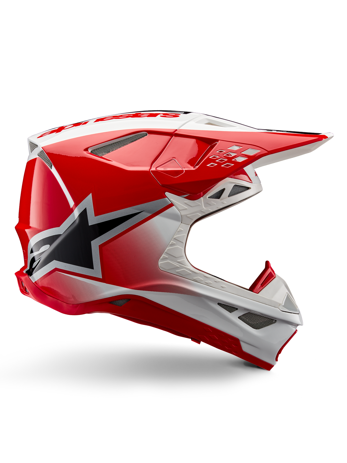 Alpinestars Supertech M10 Unite-hjelm, motocross-racerhjelm, rød og hvid højglans, set fra siden med vinklede geometriske mønstre, sort stjernegrafik, flere ventilationsåbninger med mesh og aerodynamisk design til off-road kørsel