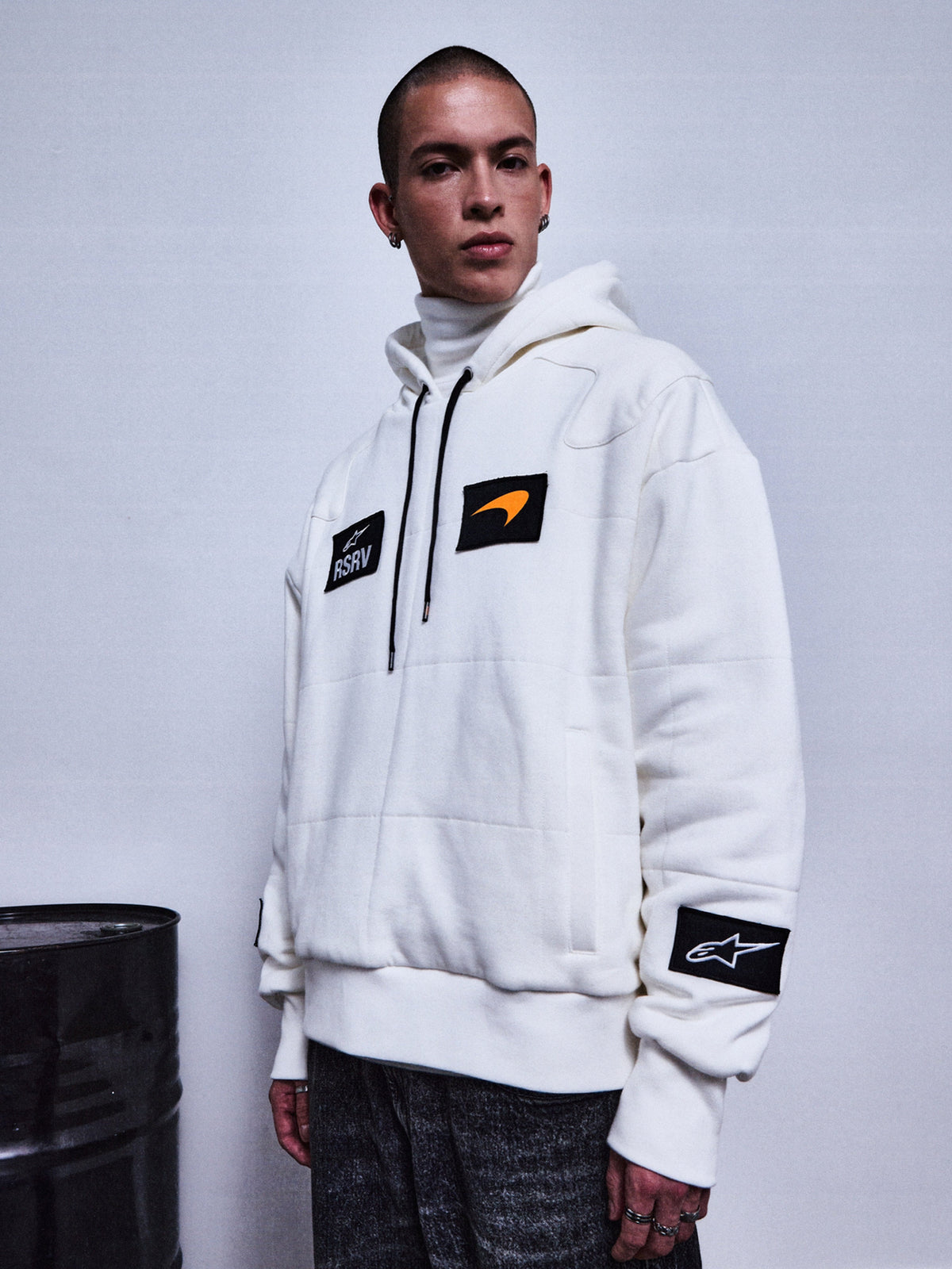 Alpinestars RSRV Rival Hoodie, hvid hættetrøje med sorte patches, unisex streetwear, premium design med orange swoosh-detalje, RSRV-kollektion, casual motorsport-inspireret stil