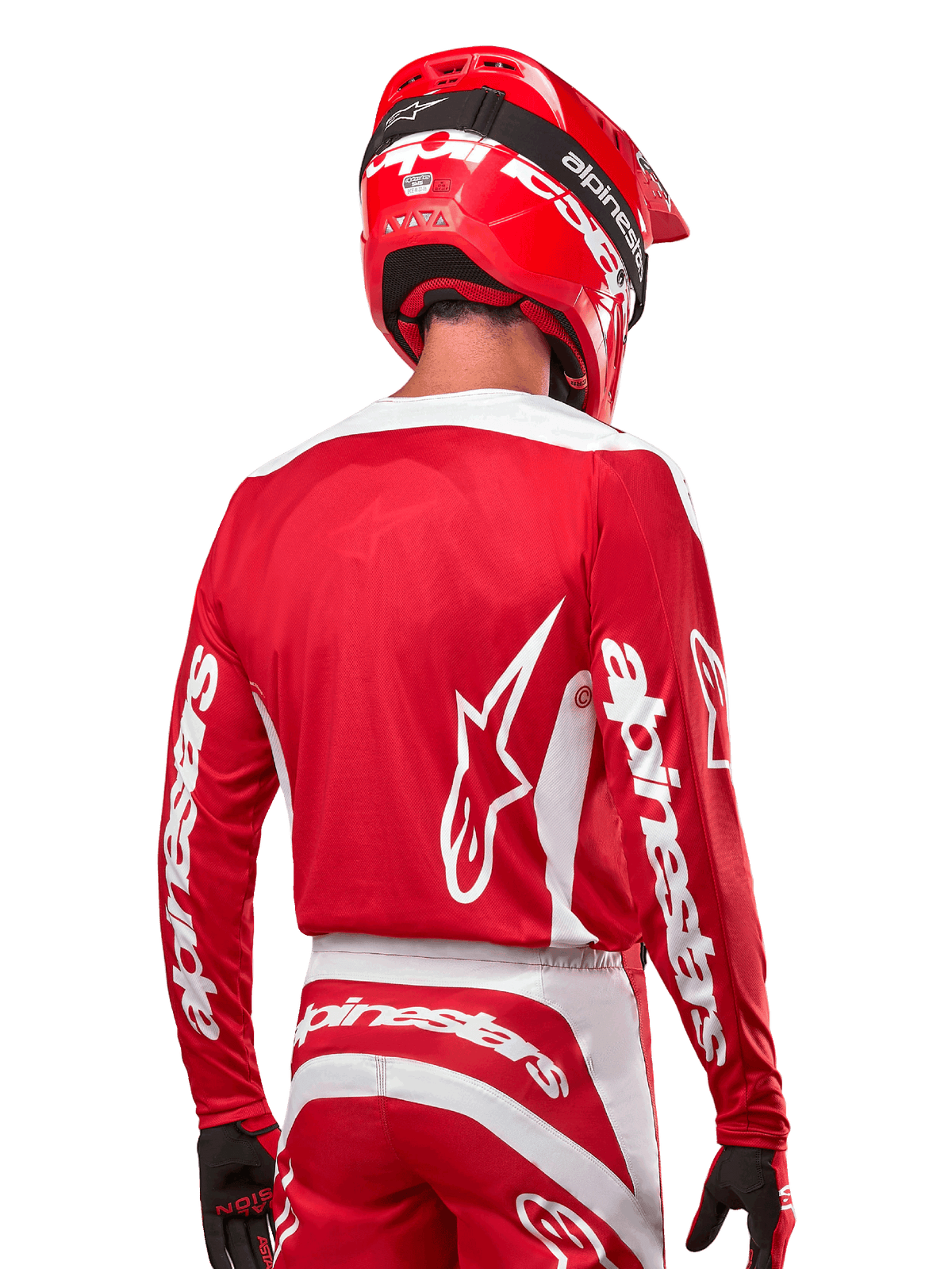 Motocross-rytter iført Alpinestars 2024 Fluid Lurv Jersey, Mars Red og hvid, set bagfra med hvidt Alpinestars-logo på ryggen og branding på ærmerne, matchende rød hjelm og sorte handsker, professionelt off-road racerudstyr