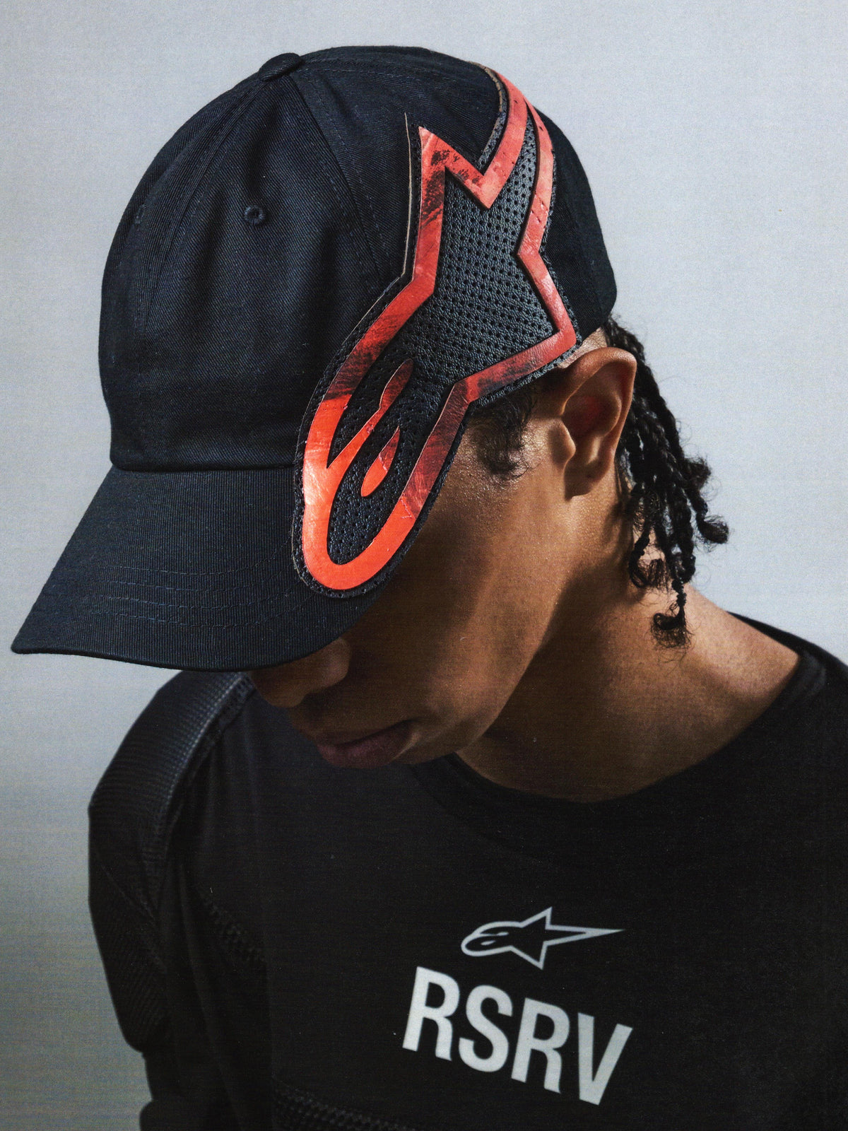 Alpinestars RSRV Lowside Hat, sort kasket med rød og sort flammemønster, unisex streetwear cap, premium konstruktion, RSRV luksuslinje