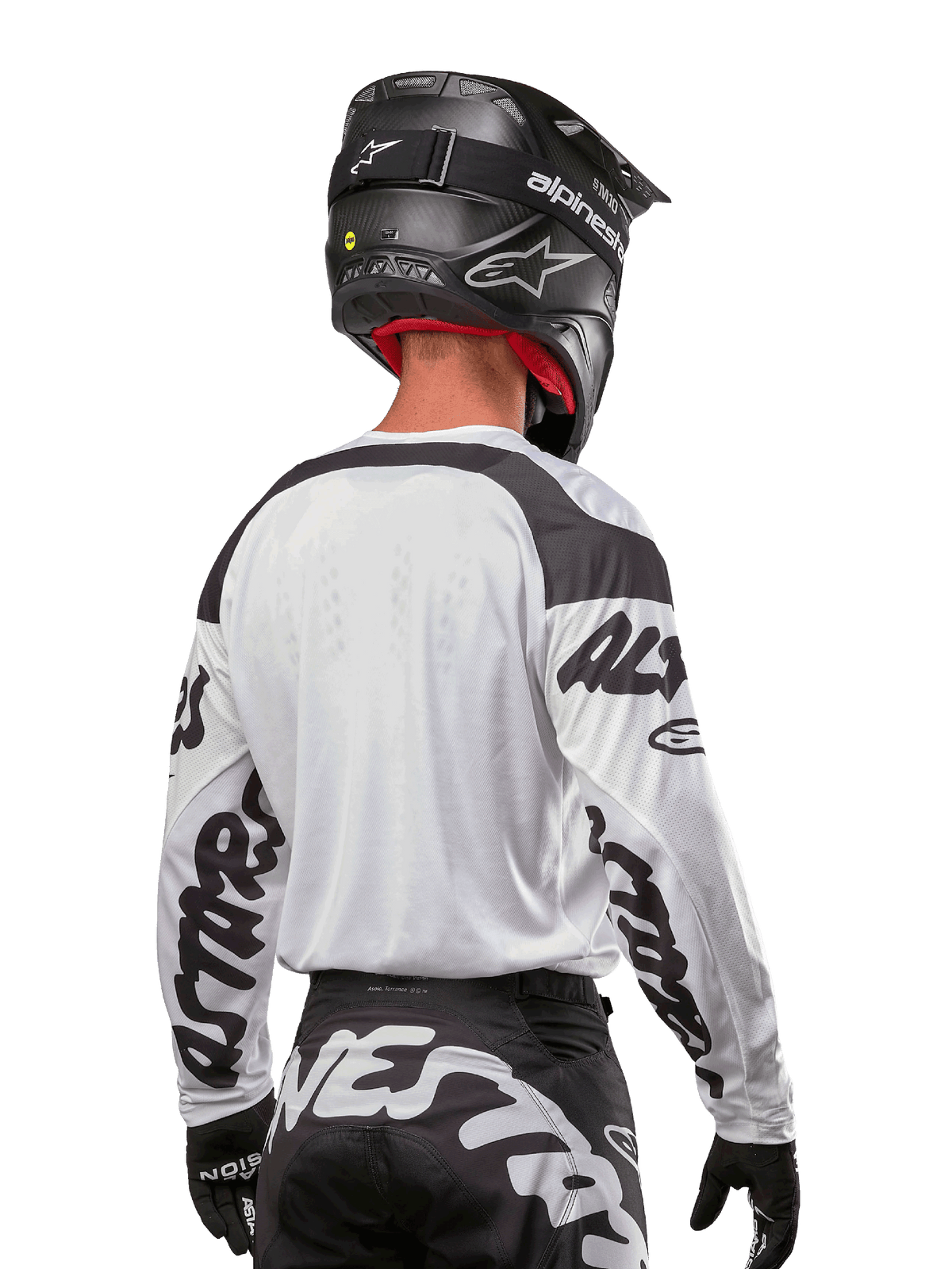 Alpinestars 2024 Racer Hana trøje, hvid og sort, set bagfra med ergonomisk pasform og markant branding på ærmerne, kombineret med en sort motocrosshjelm og matchende sort-hvide bukser, højtydende racerudstyr til terrænkørsel