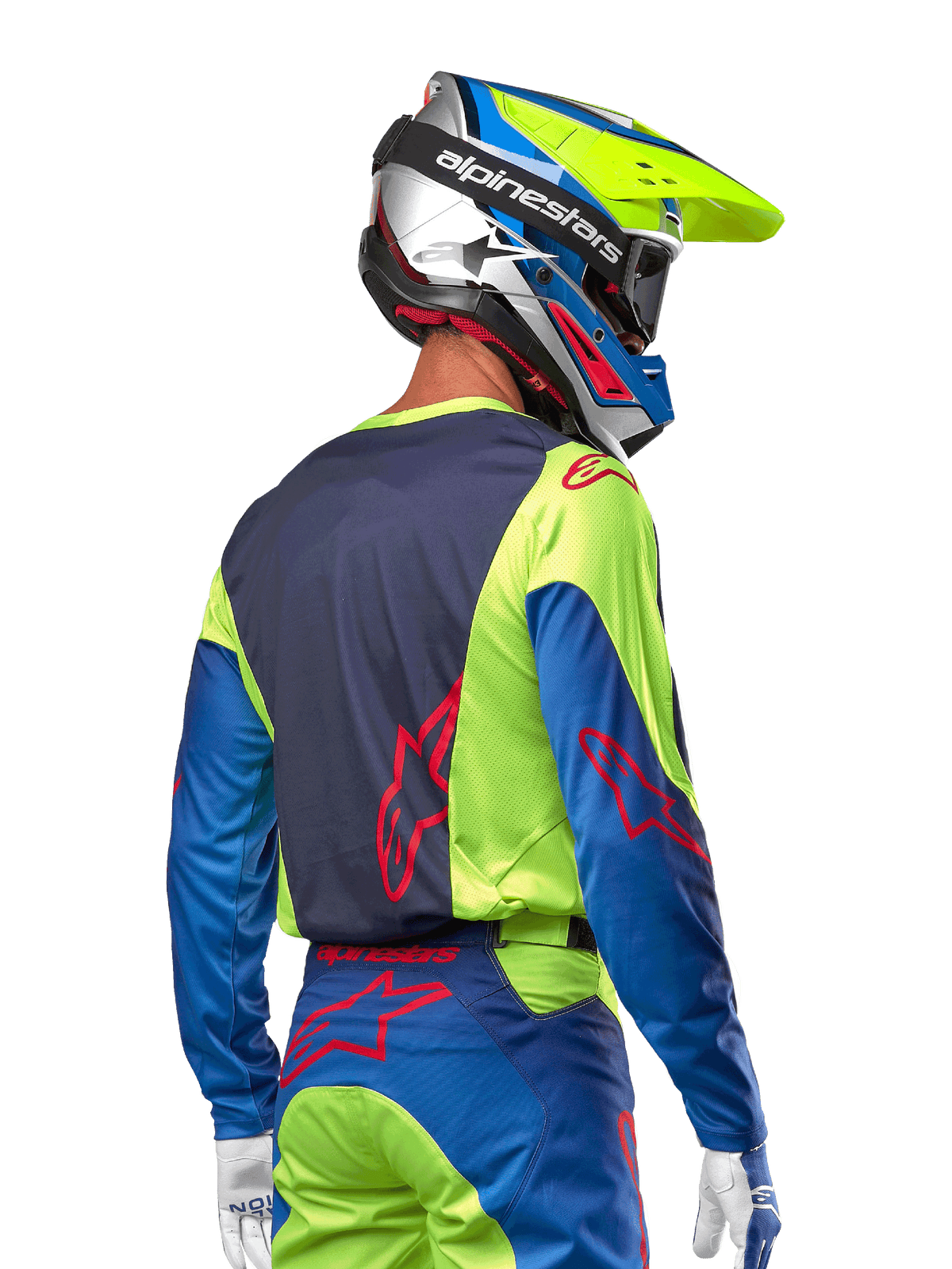 Alpinestars motocrosskører iført 2024 Racer Hoen trøje i Yellow Fluo og Blue Night Navy, med et rødt stjernelogo på ryggen, matchende motocrossbukser og en koordineret racinghjelm, set bagfra, der fremviser det ergonomiske design til off-road kørsel