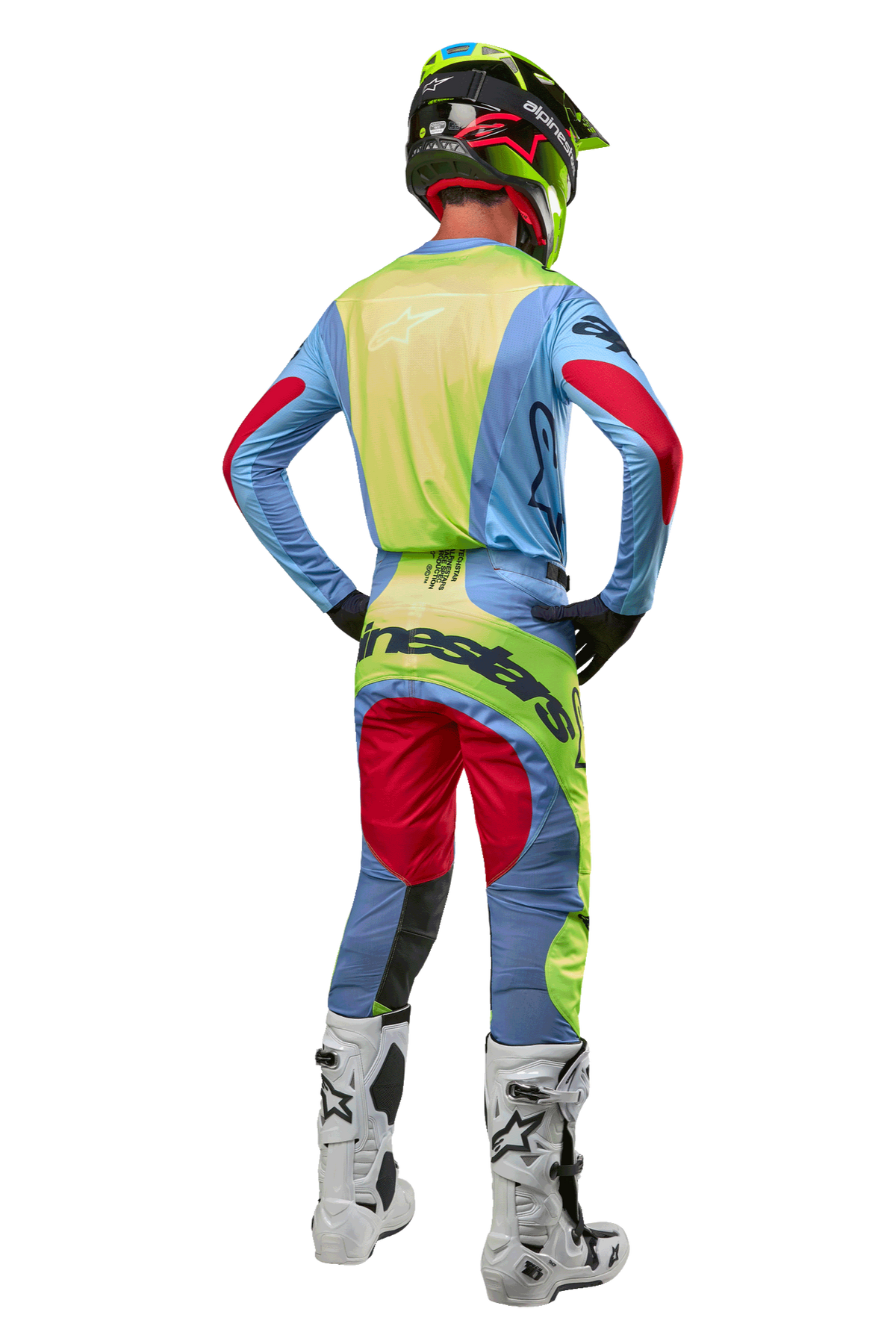 Alpinestars motocrosskører set bagfra, iført 2024 Techstar Ocuri bukser og matchende trøje, lyseblå, neongul og rød, hvide og sorte støvler, sort hjelm med neondetaljer, koordineret Alpinestars-udstyr til terrænkørsel