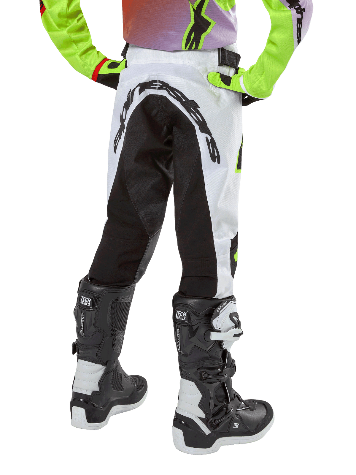 Alpinestars Youth 2024 Racer Lucent Pants, Motocross Pants, White and Black with Neon accents, back view showing large rear stretch panel and Alpinestars logo, worn with black and white Alpinestars Tech Series boots.