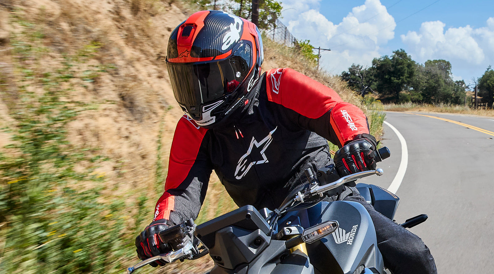 Rider wearing Alpinestars T-SPS V2 Waterproof Jacket on his honda naked motorbike. 