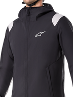 Alpinestars A-Dura Rain Jacket, sort vandtæt cykeljakke med hætte, 2,5-lags materiale, hvidt logo på brystet og hvide detaljer på skuldrene, front YKK-lynlås og mesh-forede lommer, designet til mountainbike og beskyttelse i al slags vejr