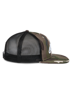 Alpinestars Corp Trucker kasket, set fra siden, Grøn Camo og sort, flad skygge med camo-print, sorte mesh-paneler bagpå, hvidt broderet logo, afslappet motorsport-hovedbeklædning