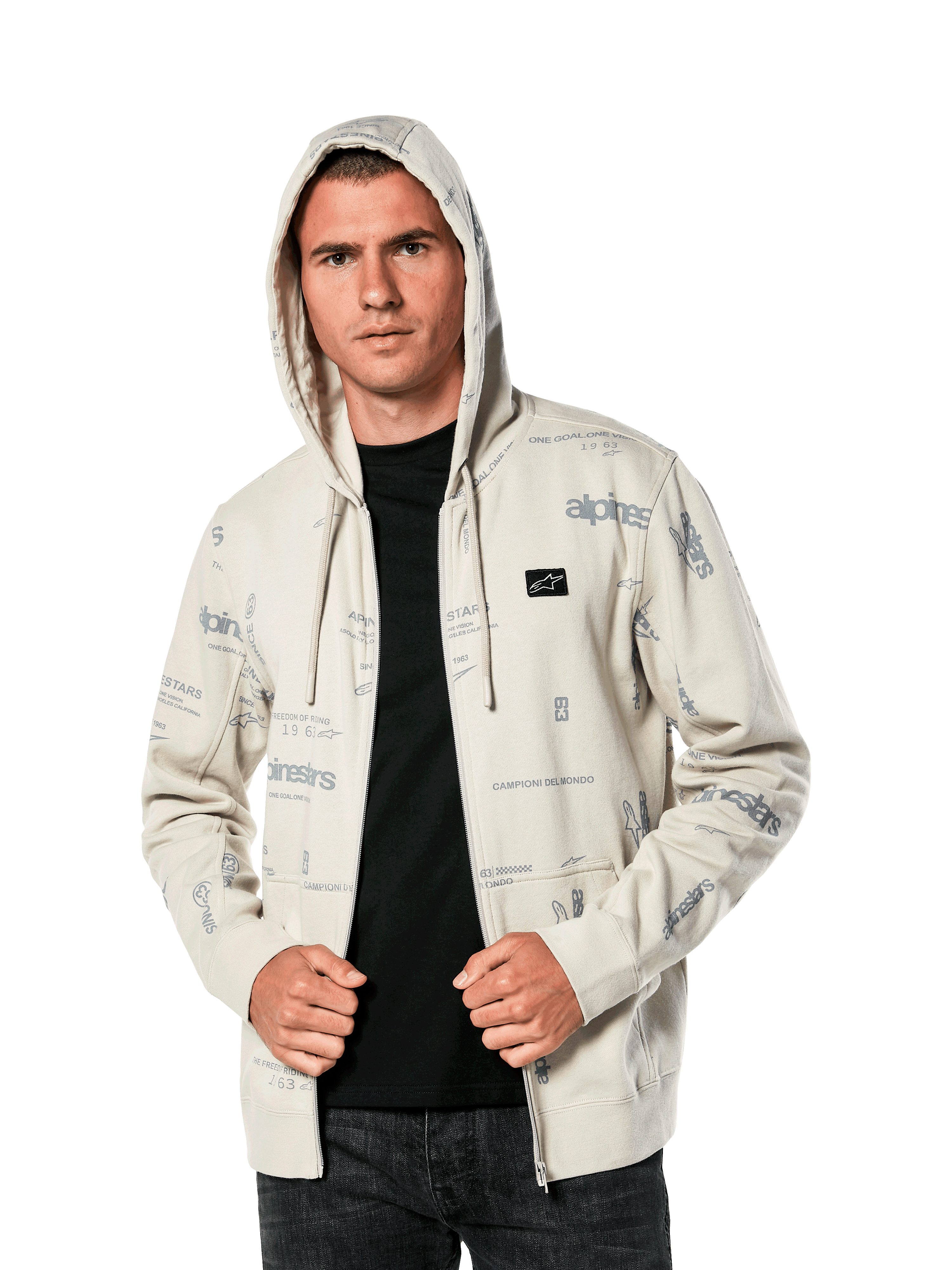 Alpinestars Plenitude hættetrøje, afslappet sportstøj, Off White fleece med lynlås foran og all-over grå logo-grafik, bæres af en mand med hætten oppe over en sort trøje, lille logomærke på brystet og kængurulomme