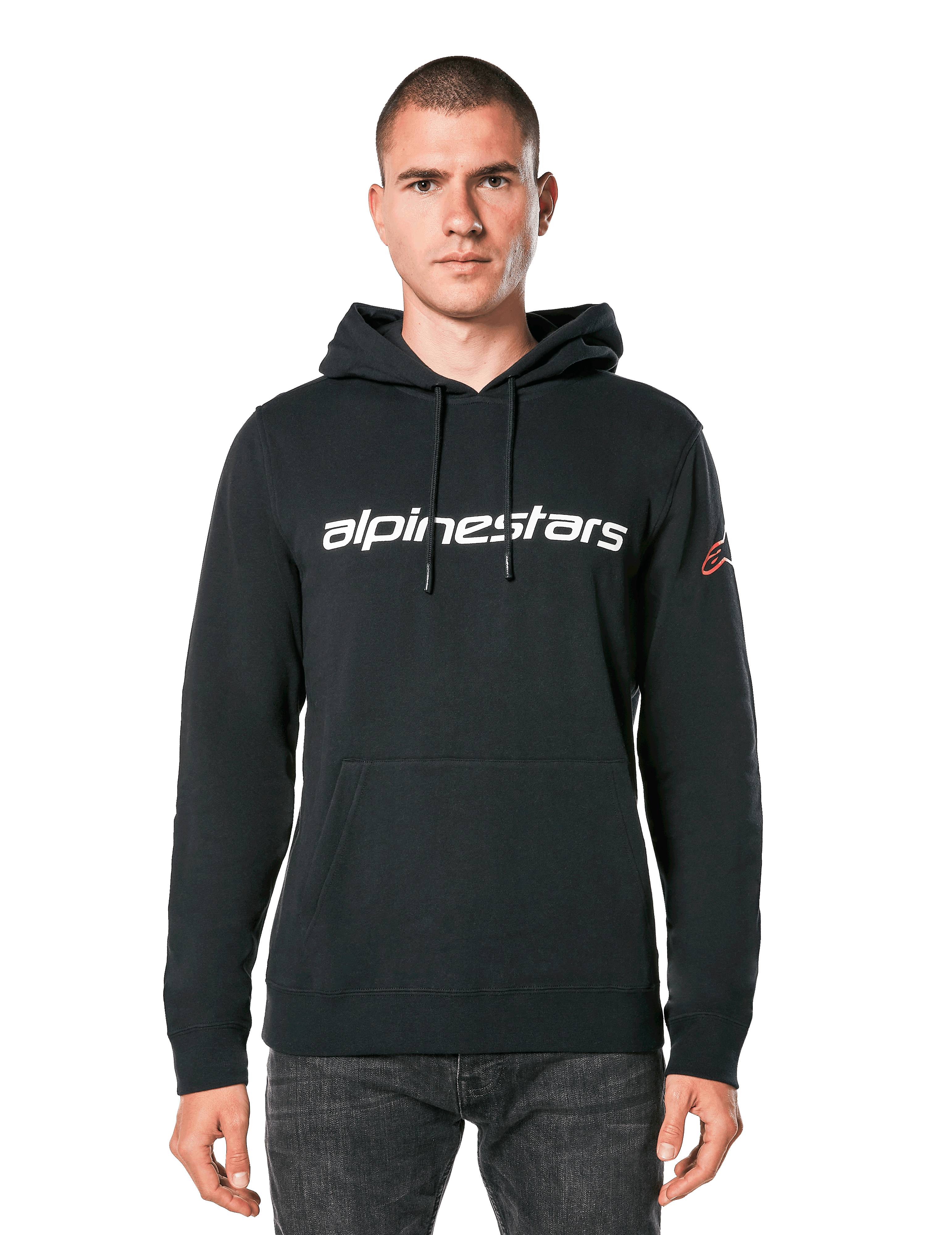 Alpinestars Linear Wordmark V3 hættetrøje, sort pullover, hvidt Alpinestars-tekstlogo på brystet, rødt Ageless-logo på ærmet, kængurulomme foran, hætte med snøre, båret af mandlig model, afslappet motorsport-inspireret streetwear