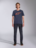 Alpinestars Ageless 2.0 CSF Tee, Short Sleeve T-Shirt, Navy Blue with Orange Alpinestars Logo, worn by model with dark jeans and sneakers, Casual Motorsport Streetwear