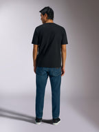 Alpinestars Ageless Shadow CSF Tee, kortærmet T-shirt, sort, set bagfra, båret med blå jeans, afslappet motorsport streetwear